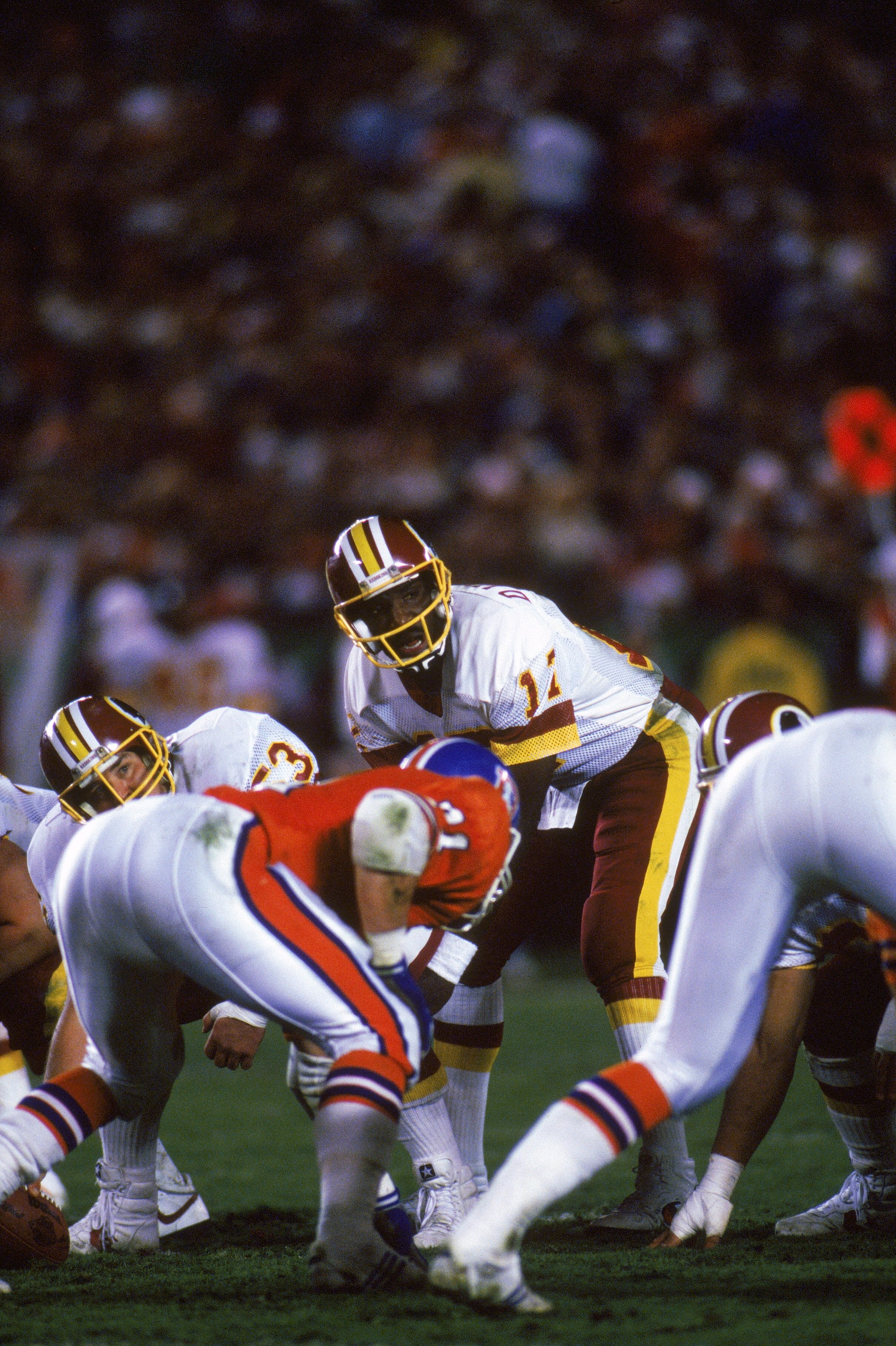 SAN DIEGO - JANUARY 31:  Quarterback Doug Williams #17 of the Washington Redskins looks to his left as he calls a play at the line of scrimmage during Super Bowl XXII against the Denver Broncos at Jack Murphy Stadium on January 31, 1988 in San Diego, Cali