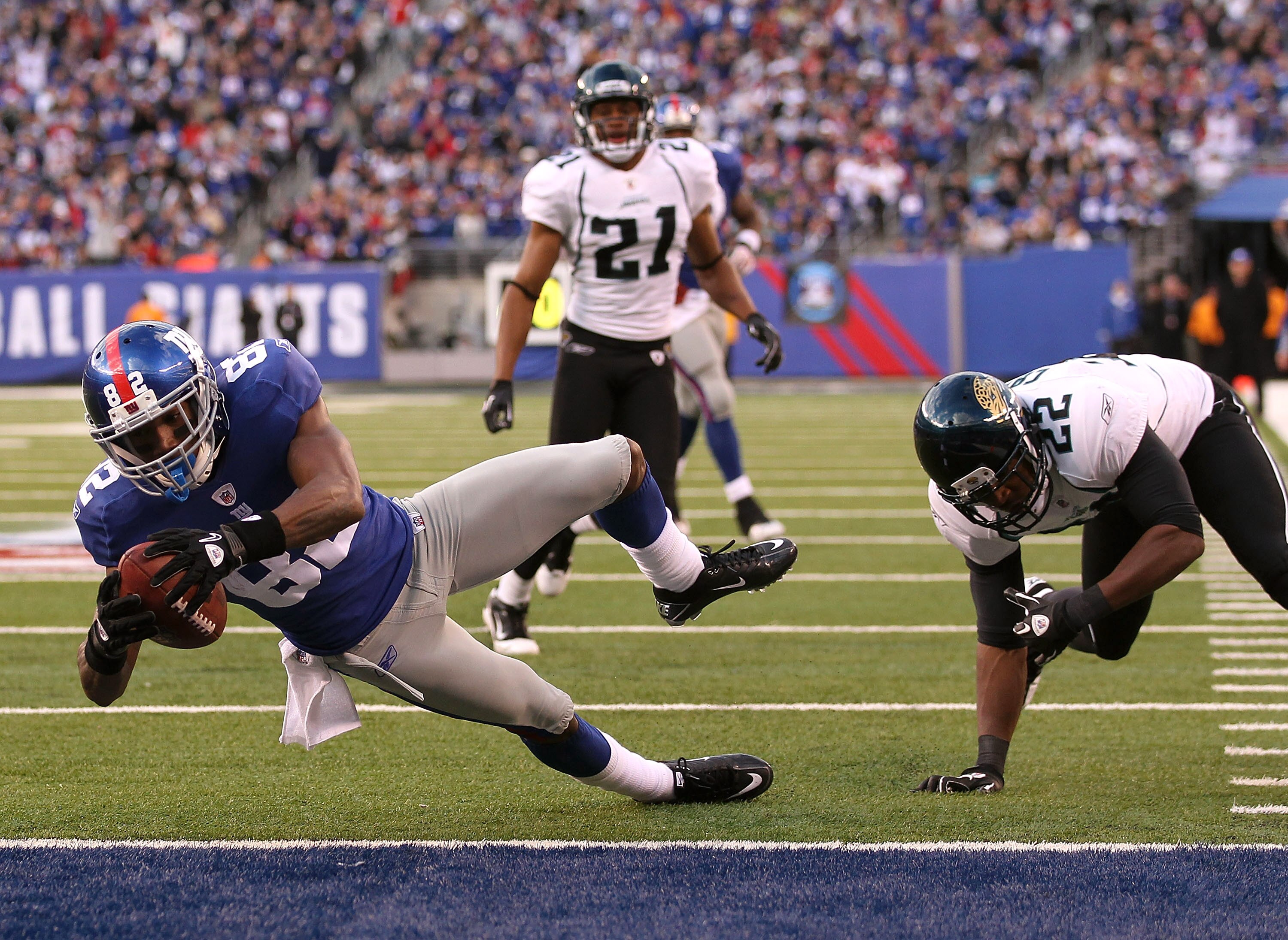 EAST RUTHERFORD, NJ - NOVEMBER 28:  Mario Manningham #82 of the New York Giants scores a touchdown in the fourth Quarter as Don Carey #22 of the Jacksonville Jaguars misses the tackle during their game on November 28, 2010 at The New Meadowlands Stadium i