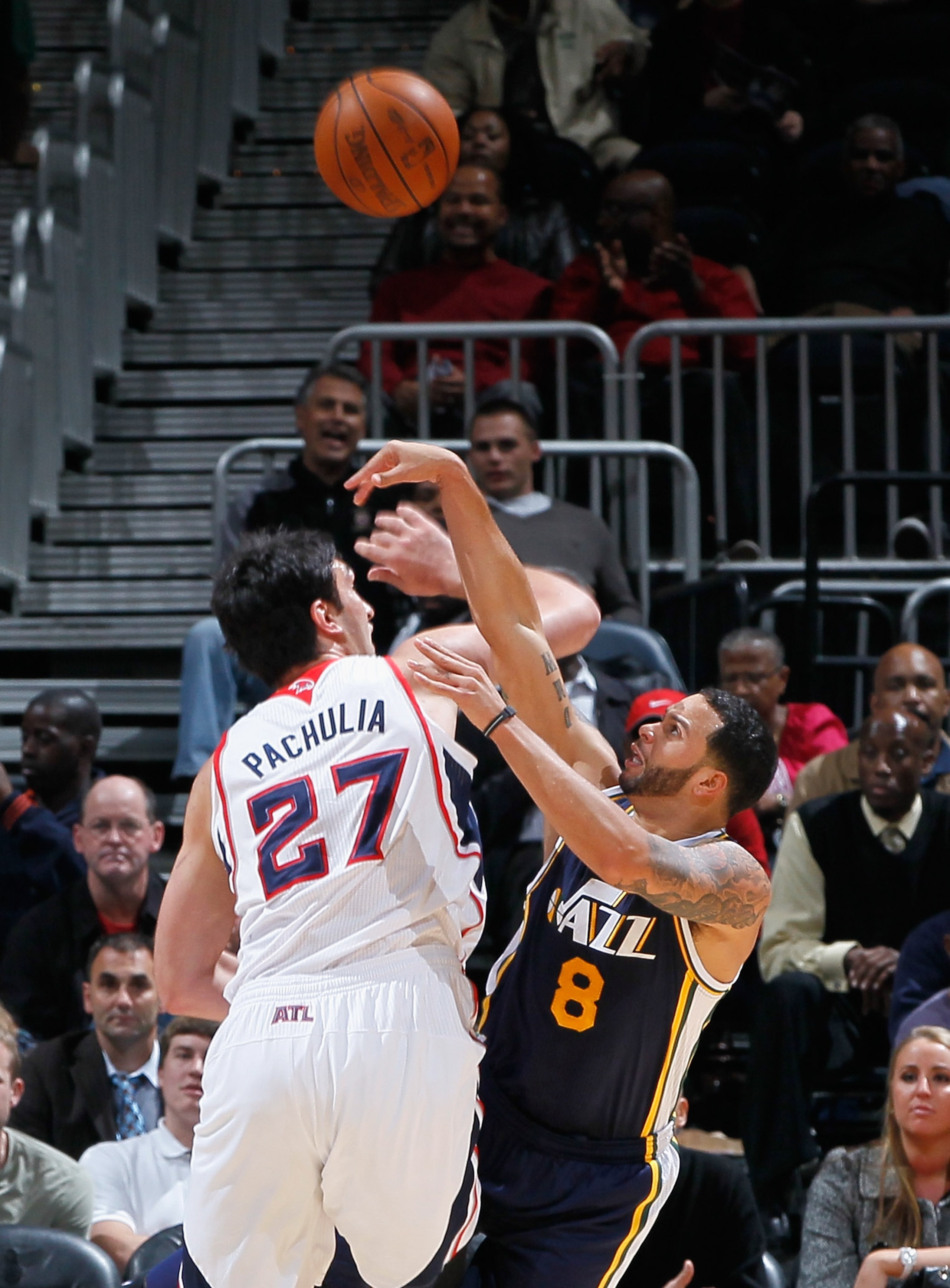 ATLANTA - NOVEMBER 12:  Zaza Pachulia #27 of the Atlanta Hawks fouls Deron Williams #8 of the Utah Jazz at Philips Arena on November 12, 2010 in Atlanta, Georgia.  NOTE TO USER: User expressly acknowledges and agrees that, by downloading and/or using this