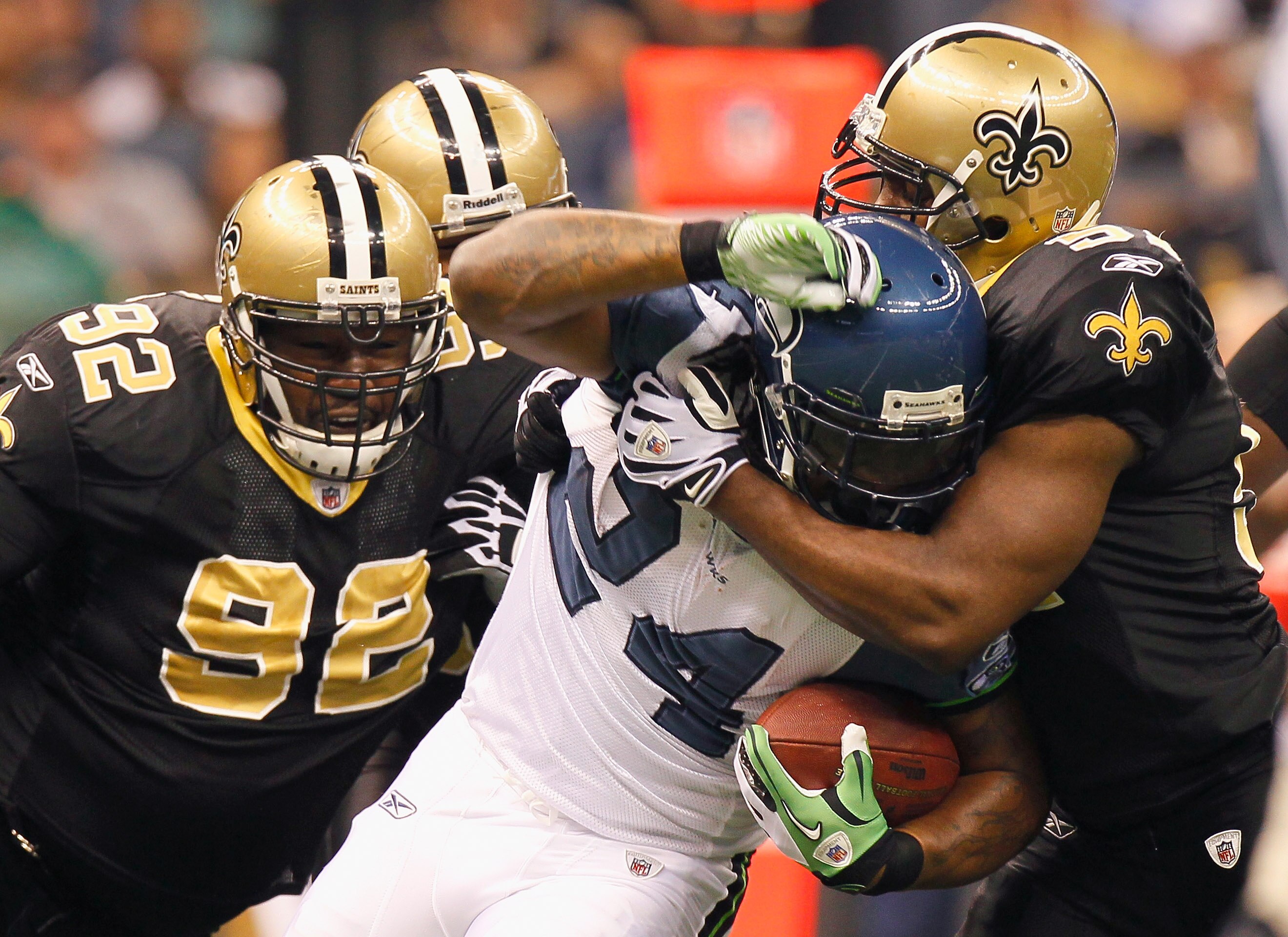 NEW ORLEANS - NOVEMBER 21:  Jonathan Vilma #51 and Remi Ayodele #92 of the New Orleans Saints tackle Marshawn Lynch #24 of the Seattle Seahawks at Louisiana Superdome on November 21, 2010 in New Orleans, Louisiana.  (Photo by Kevin C. Cox/Getty Images)