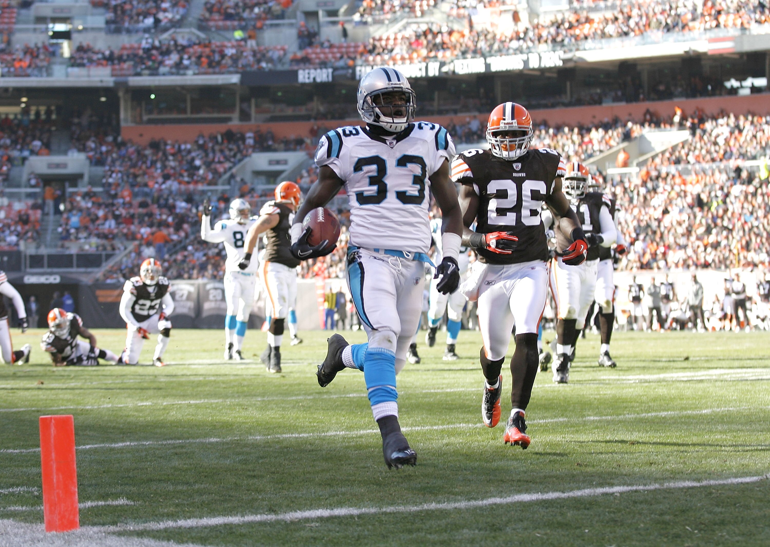 CLEVELAND - NOVEMBER 28:  Running back Mike Goodson #33 of the Carolina Panthers scores a touchdown in front of defensive back Abram Elam #26 of the Cleveland Browns at Cleveland Browns Stadium on November 28, 2010 in Cleveland, Ohio.  (Photo by Matt Sull