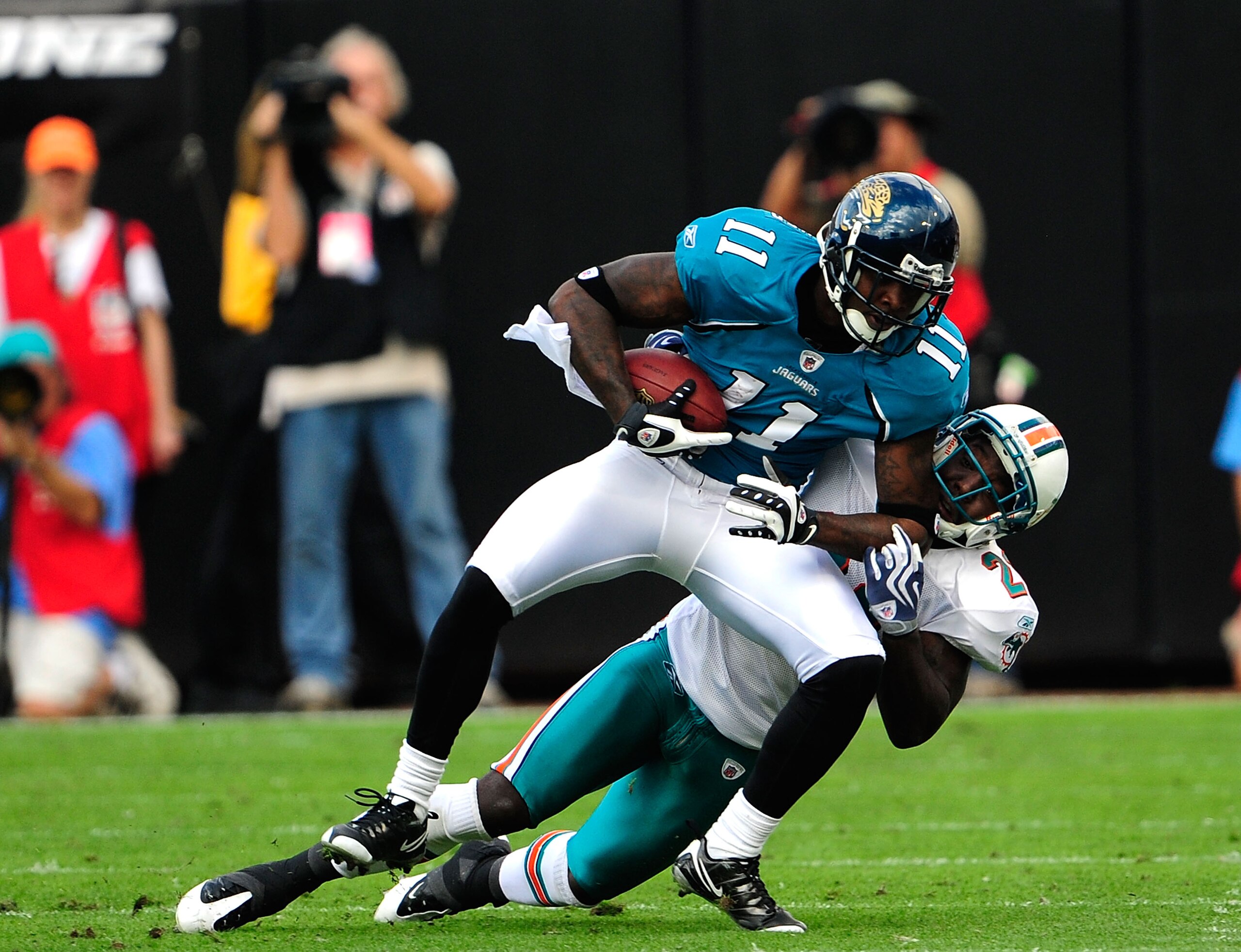 JACKSONVILLE, FL - DECEMBER 13:  Mike Sims-Walker #11 of the Jacksonville Jaguars is tackled by Gibril Wilson #28 of the Miami Dolphins during the game at Jacksonville Municipal Stadium on December 13, 2009 in Jacksonville, Florida.  The Dolpnins won 14-1