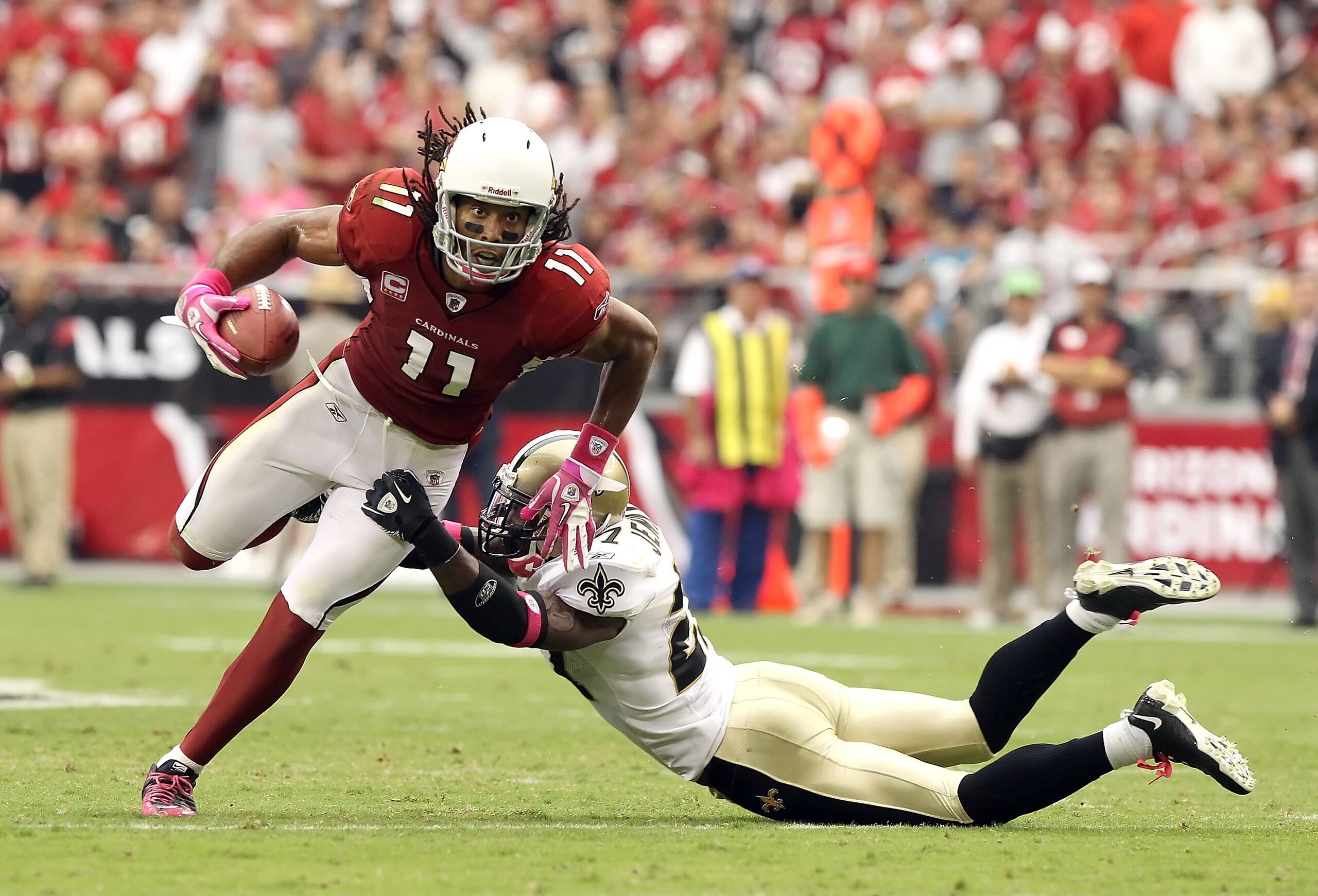 GLENDALE, AZ - OCTOBER 10:   Wide receiver Larry Fitzgerald #11 of the Arizona Cardinals runs with the football after a 8 yard reception past Malcolm Jenkins #27 of the New Orleans Saints during the second quarter of the NFL game at the University of Phoe