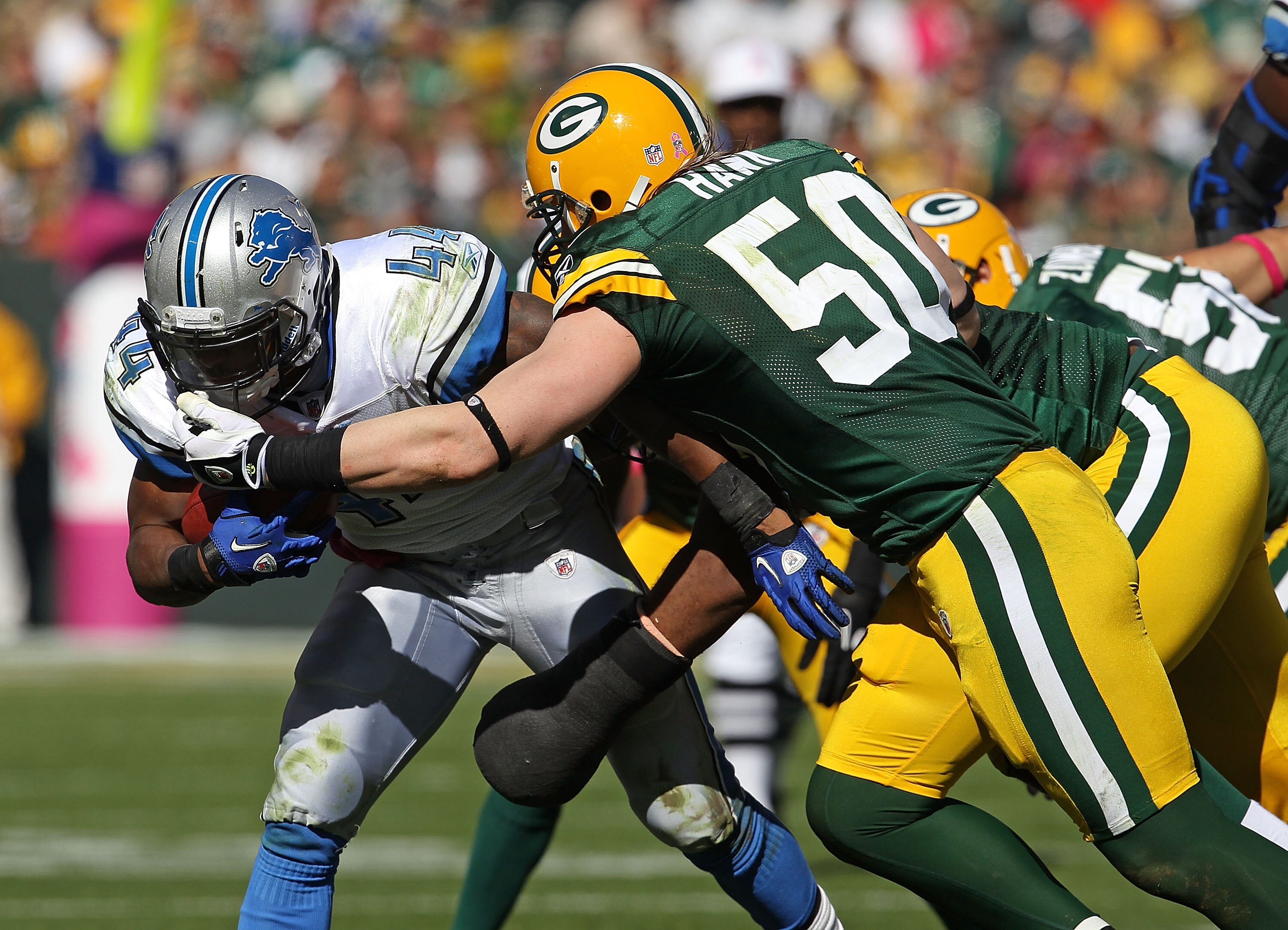 GREEN BAY, WI - OCTOBER 03: A.J. Hawk #50 of the Green Bay Packers grabs the face mask of Jahvid Best #44 of the Detroit Lions resulting in a penalty at Lambeau Field on October 3, 2010 in Green Bay, Wisconsin. The Packers defeated the Lions 28-26.  (Phot