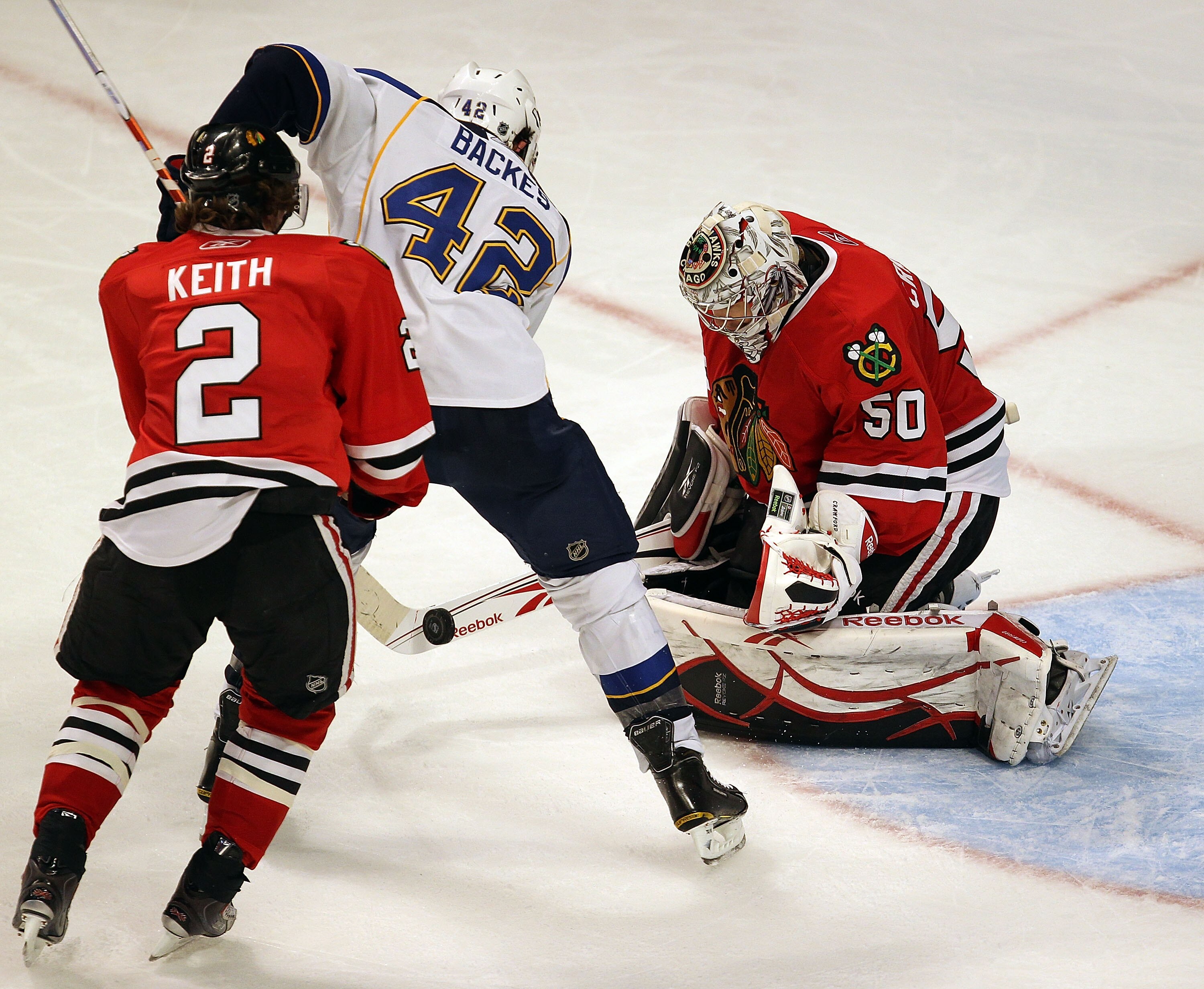 CHICAGO - NOVEMBER 30: Corey Crawford #50 of the Chicago Blackhawks stops a shot with his stick by David Backes #42 of the St. Louis Blues as teammate Duncan Keith #2 closes in at the United Center on November 30, 2010 in Chicago, Illinois. The Blackhawks