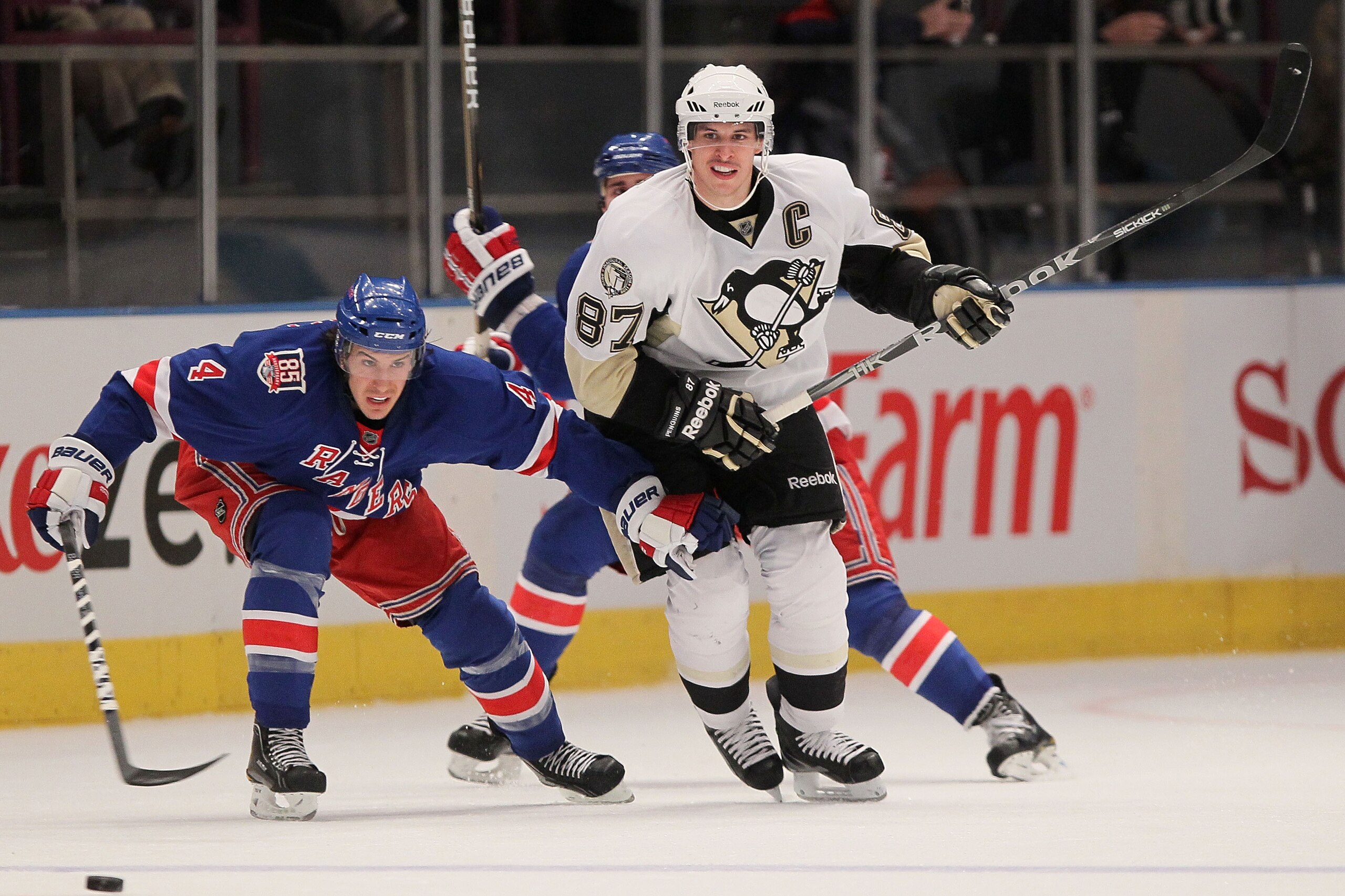 NEW YORK, NY - NOVEMBER 29:  Sidney Crosby #87 of the Pittsburgh Penguins chases the puck against Michael Del Zotto #4 of the New York Rangers during their game on November 29, 2010 at Madison Square Garden in New York City.  (Photo by Chris McGrath/Getty