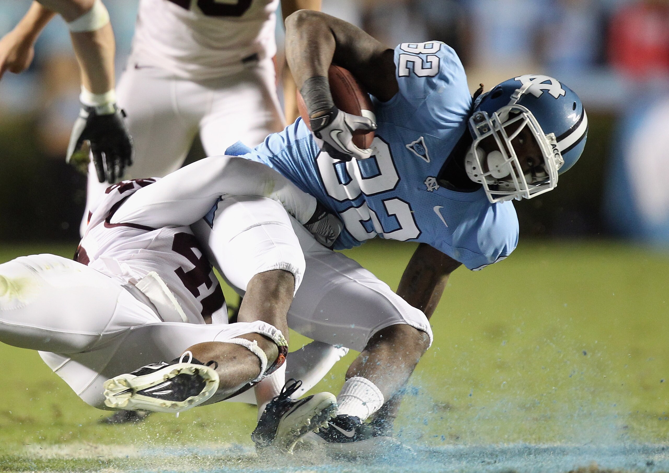 CHAPEL HILL, NC - NOVEMBER 13:  The defense of the Virginia Tech Hokies takes down Todd Harrelson #82 of the North Carolina Tar Heels hard to the ground during their game at Kenan Stadium on November 13, 2010 in Chapel Hill, North Carolina.  (Photo by Str