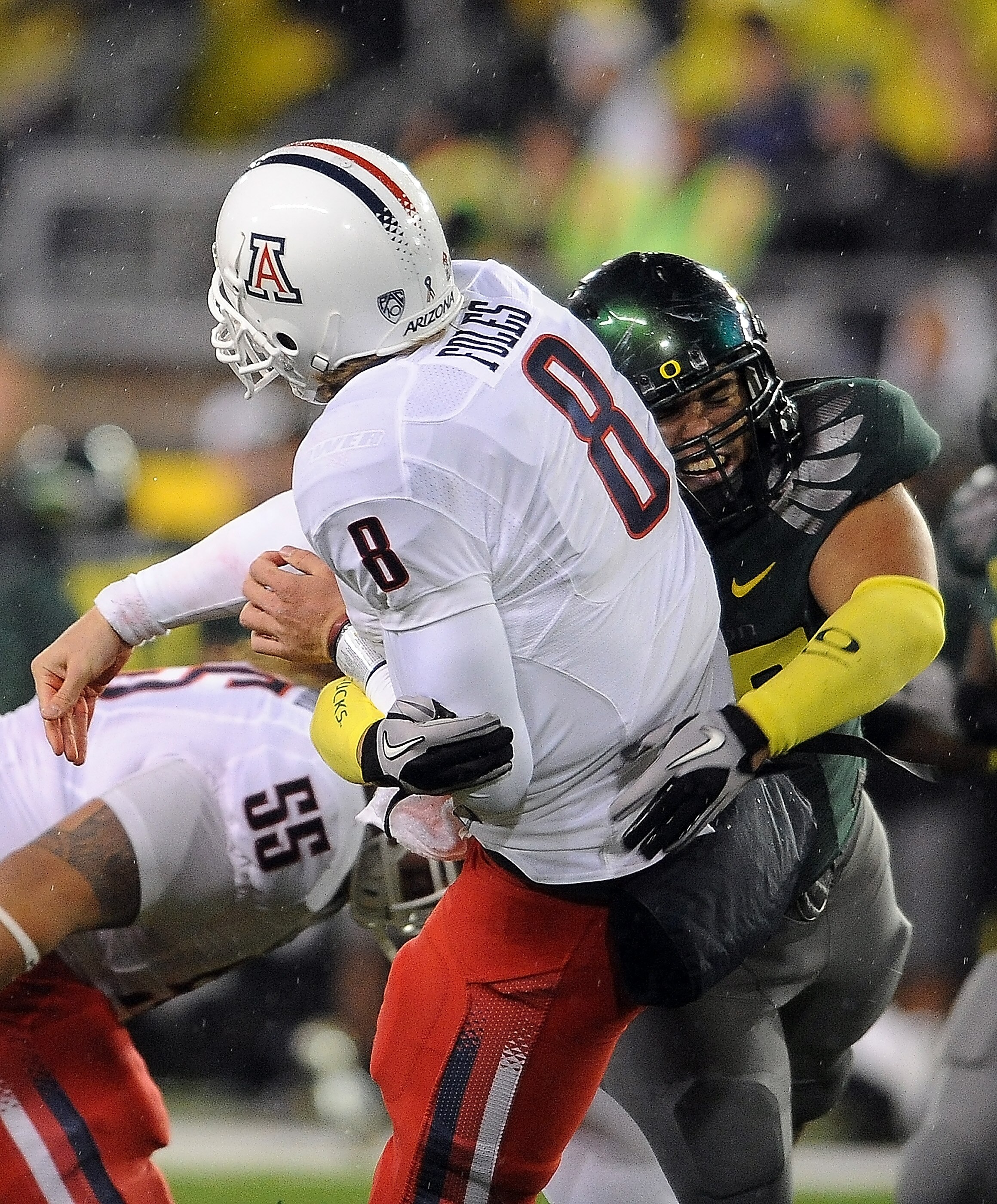 EUGENE, OR - NOVEMBER 26: Quarterback Nick Foles #8 of the Arizona Wildcats is hit by defensive tackle Zac Clark #99 of the Oregon Ducks in the third quarter of the game at Autzen Stadium on November 26, 2010 in Eugene, Oregon. The Ducks won the game 48-2