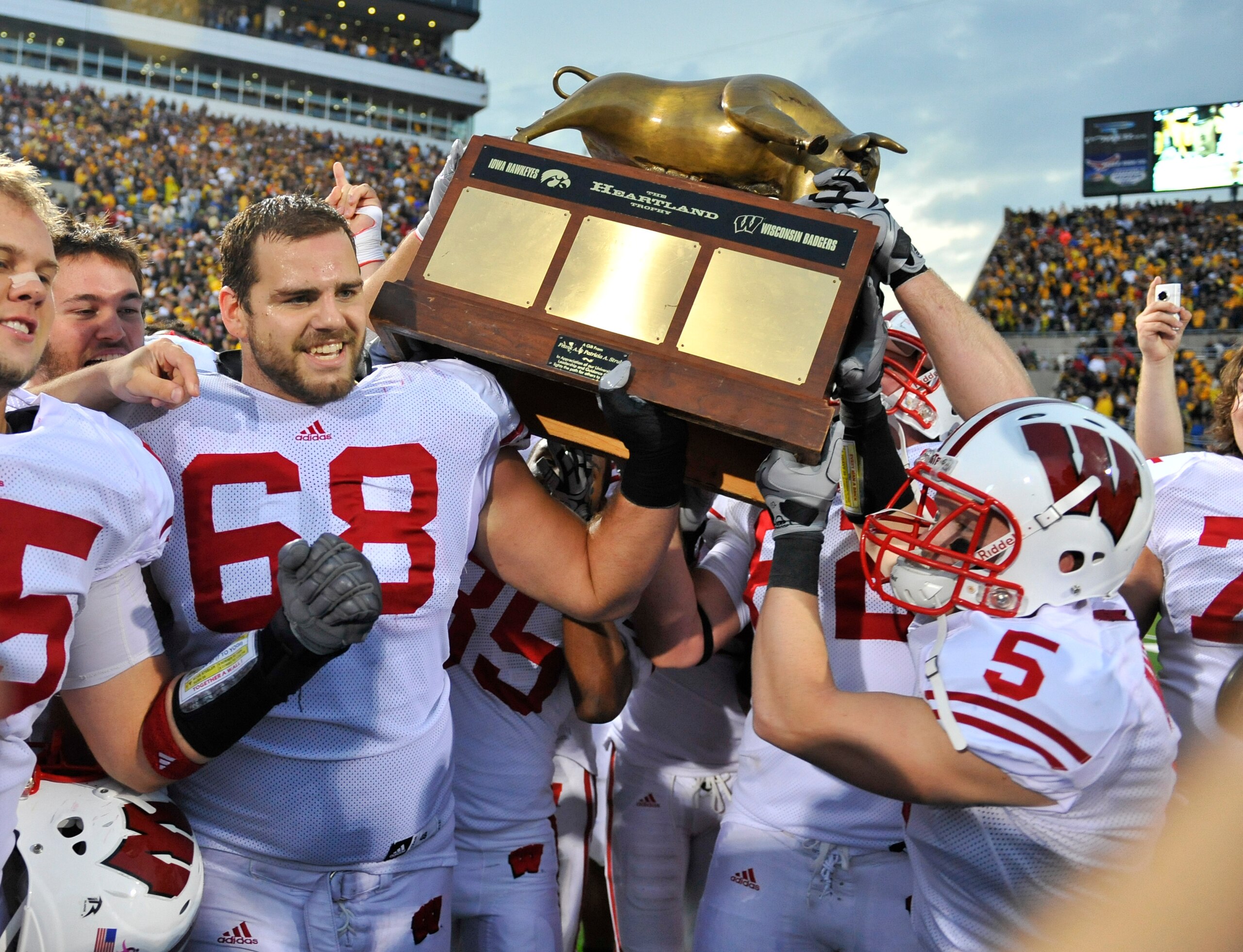 IOWA CITY, IA - OCTOBER 23: Offensive lineman Gabe Carimi #68 for the Wisconsin Badger holds the Heartland Trophy with his teammates as they celebrate their victory of the University of Iowa Hawkeyes at Kinnick Stadium on October 23, 2010 in Iowa City, Io IOWA CITY, IA - OCTOBER 23: Offensive lineman Gabe Carimi #68 for the Wisconsin Badger holds the Heartland Trophy with his teammates as they celebrate their victory of the University of Iowa Hawkeyes at Kinnick Stadium on October 23, 2010 in Iowa City, Io