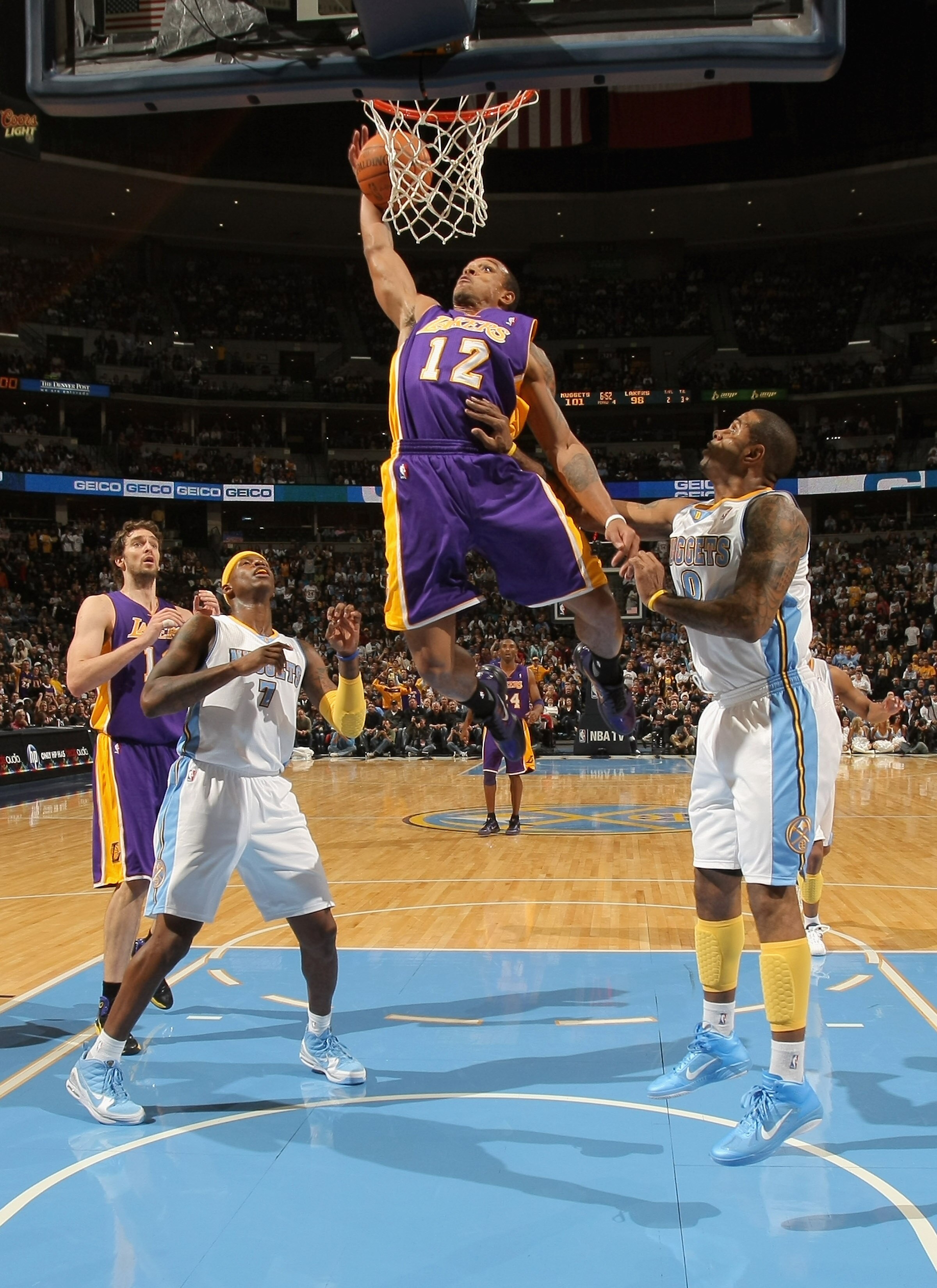 DENVER - NOVEMBER 11:  Shannon Brown #12 of the Los Angeles Lakers grabs a rebound and dunks the ball between Al Harrington #7 and Gary Forbes #0 of the Denver Nuggets at the Pepsi Center on November 11, 2010 in Denver, Colorado. The Nuggets defeated the