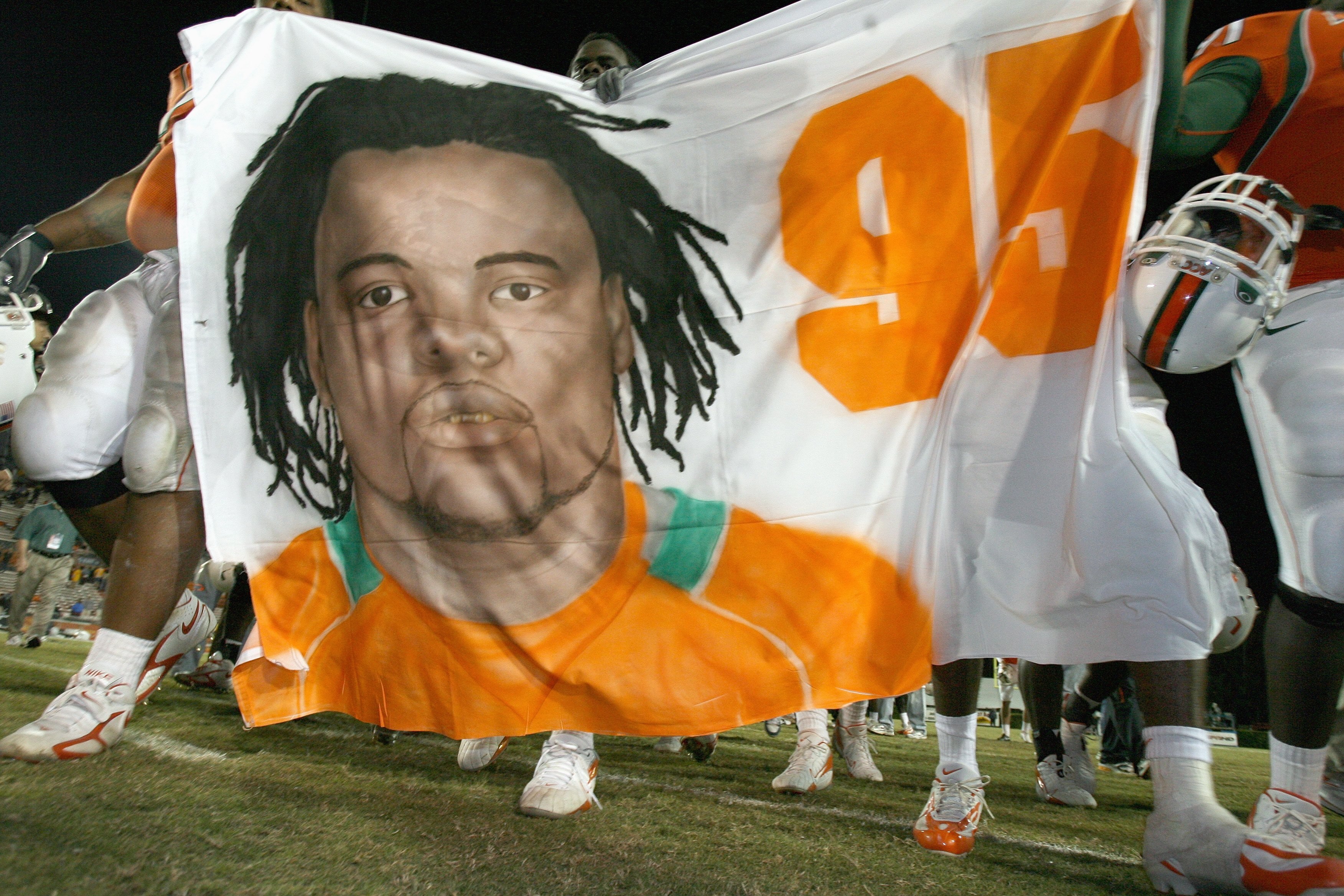 MIAMI - NOVEMBER 23: Teammates of Bryan Pata #95 of the University of Miami Hurricanes walks to mid-field after defeating the Boston College Golden Eagles at the Orange Bowl Stadium on November 23, 2006 in Miami, Florida. Pata was shot and killed after pr
