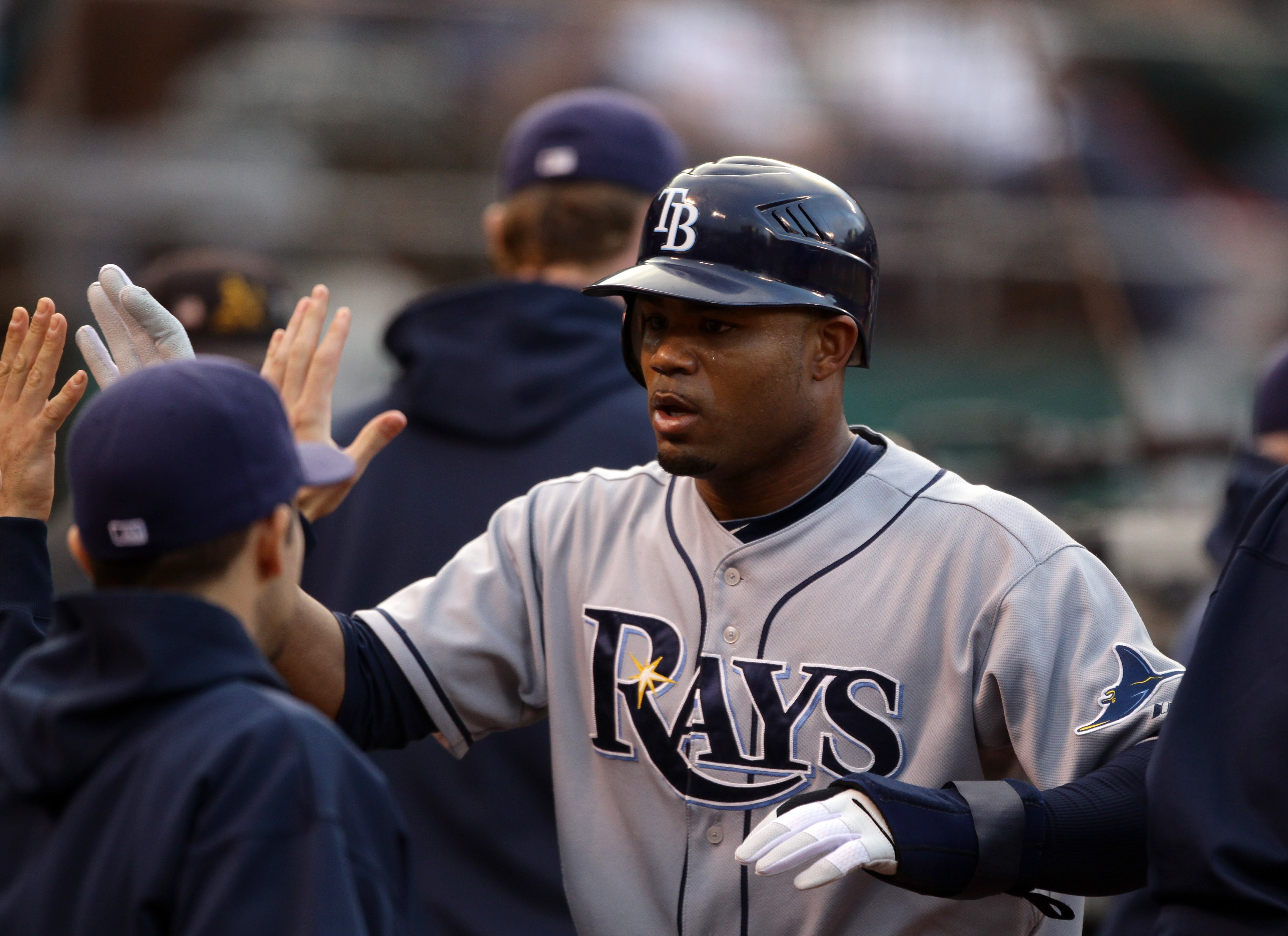 OAKLAND, CA - AUGUST 20:  Carl Crawford #13 of the Tampa Bay Rays is congratulated by teammates after he scored on a single by Matt Joyce in the first inning of their game against the Oakland Athletics at the Oakland-Alameda County Coliseum  on August 20,