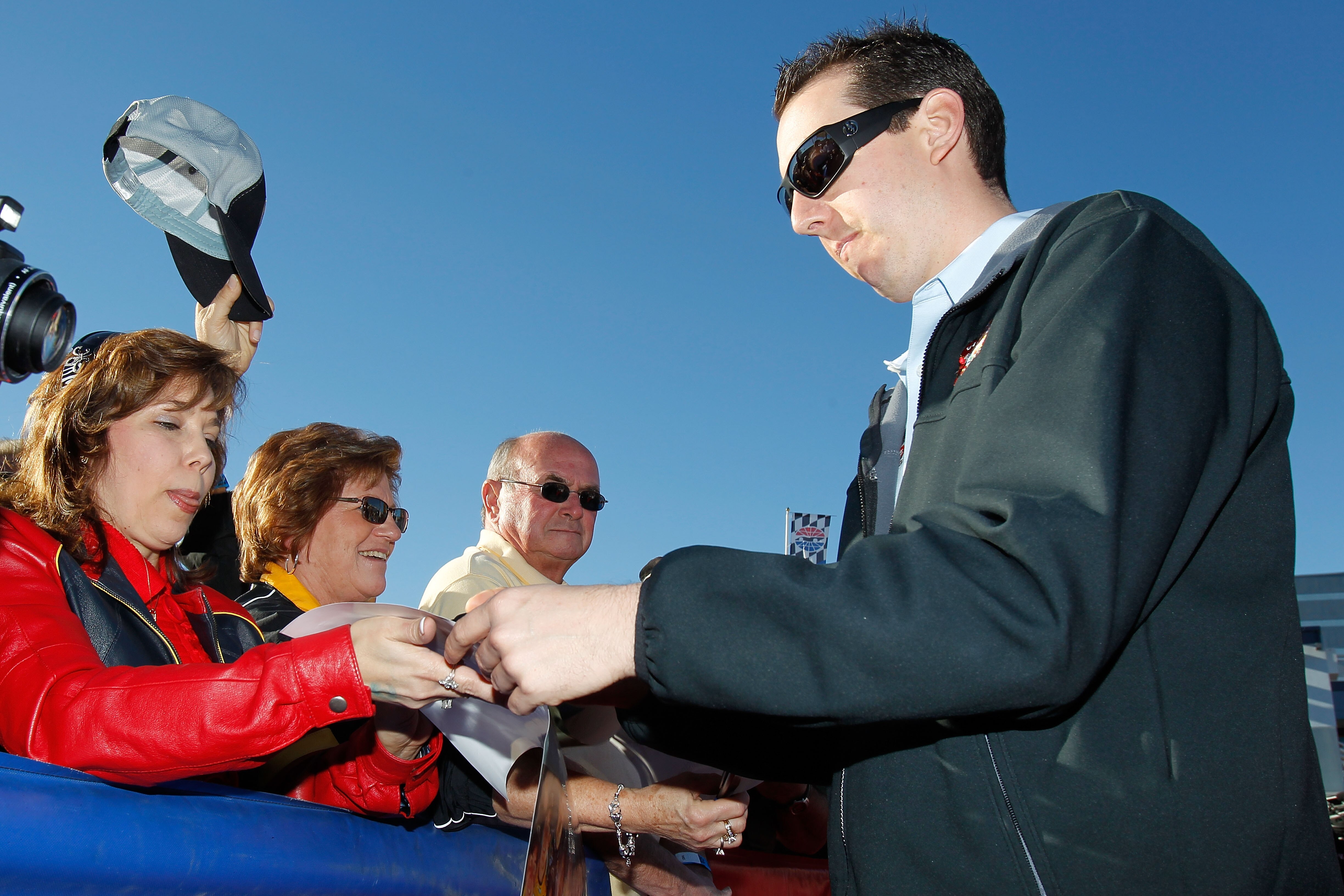 LAS VEGAS, NV - DECEMBER 01:  Kyle Busch (R), driver of the #18 M&M's Toyota, signs autographs during day 2 of the NASCAR Sprint Cup Series Champions Week at Las Vegas Motor Speedway on December 1, 2010 in Las Vegas, Nevada.  (Photo by Todd Warshaw/Getty