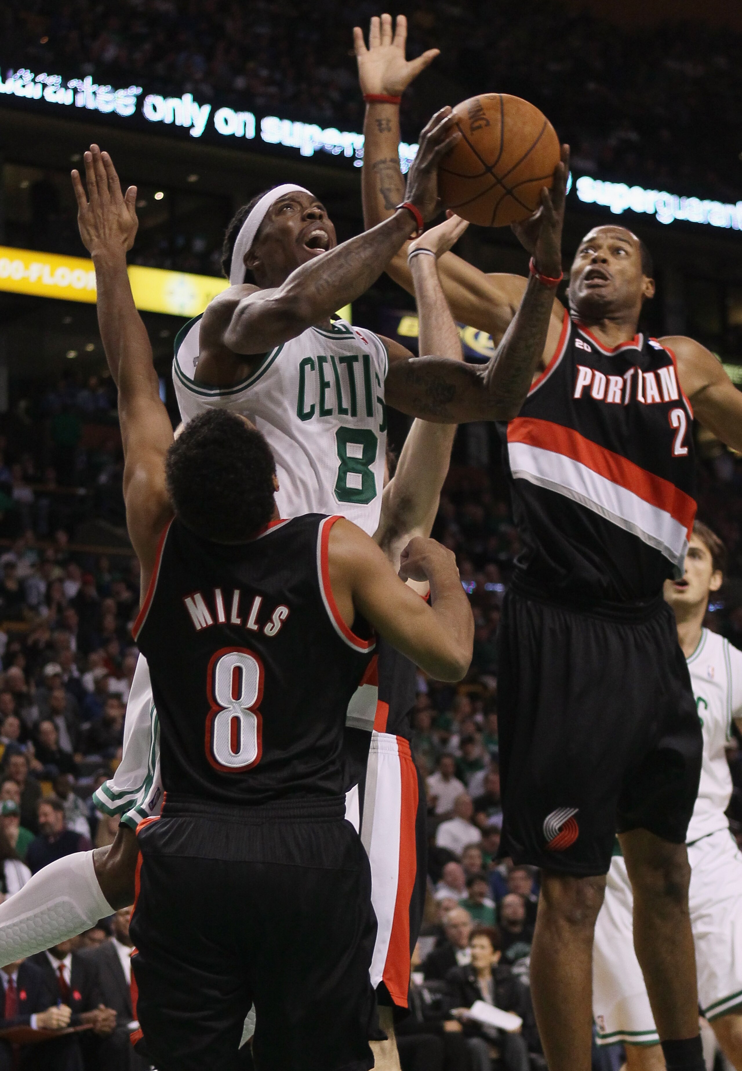 BOSTON - DECEMBER 01:  Marquis Daniels #8 of the Boston Celtics tries to take a shot as Marcus Camby #23 and Patrick Mills #8 of the Portland Trailblazers defend on December 1, 2010 at the TD Garden in Boston, Massachusetts.  NOTE TO USER: User expressly