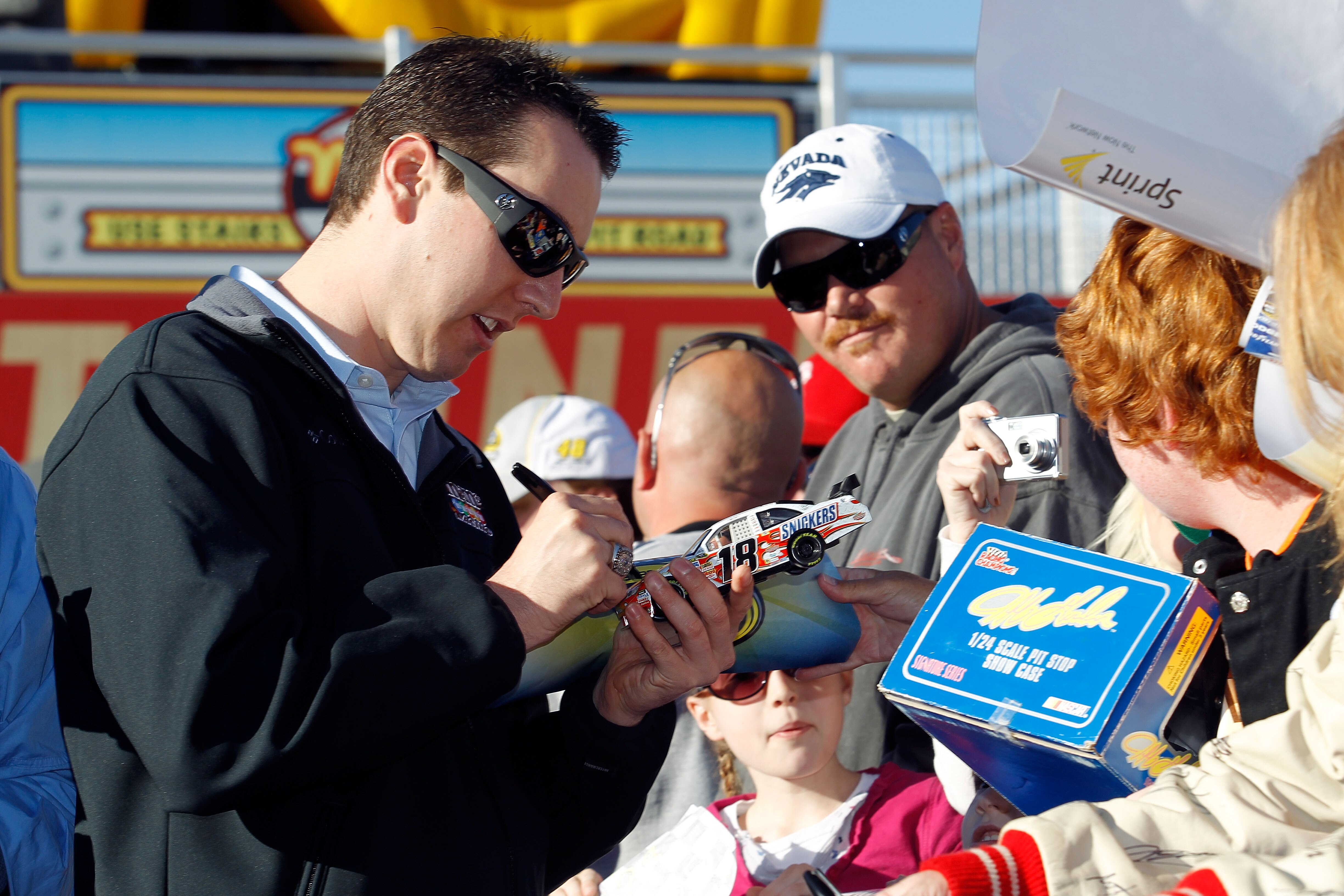 LAS VEGAS, NV - DECEMBER 01:  Kyle Busch (L), driver of the #18 M&M's Toyota, signs autographs during day 2 of the NASCAR Sprint Cup Series Champions Week at Las Vegas Motor Speedway on December 1, 2010 in Las Vegas, Nevada.  (Photo by Todd Warshaw/Getty