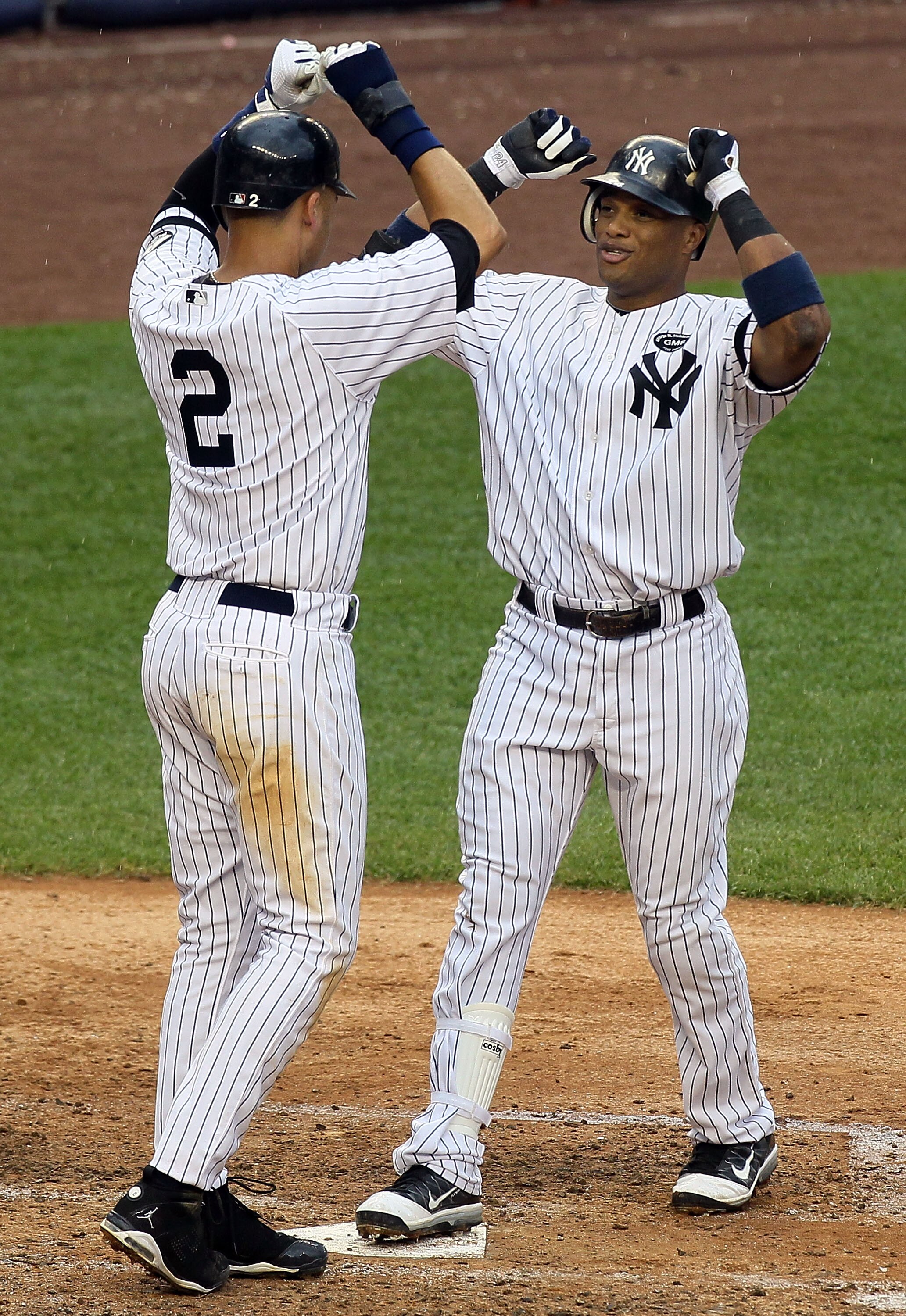 NEW YORK - AUGUST 22:  Robinson Cano #24 of the New York Yankees celebrates his fifth inning grand slam home run against the Seattle Mariners with teammate Derek Jeter #2 on August 22, 2010 at Yankee Stadium in the Bronx borough of New York City.  (Photo