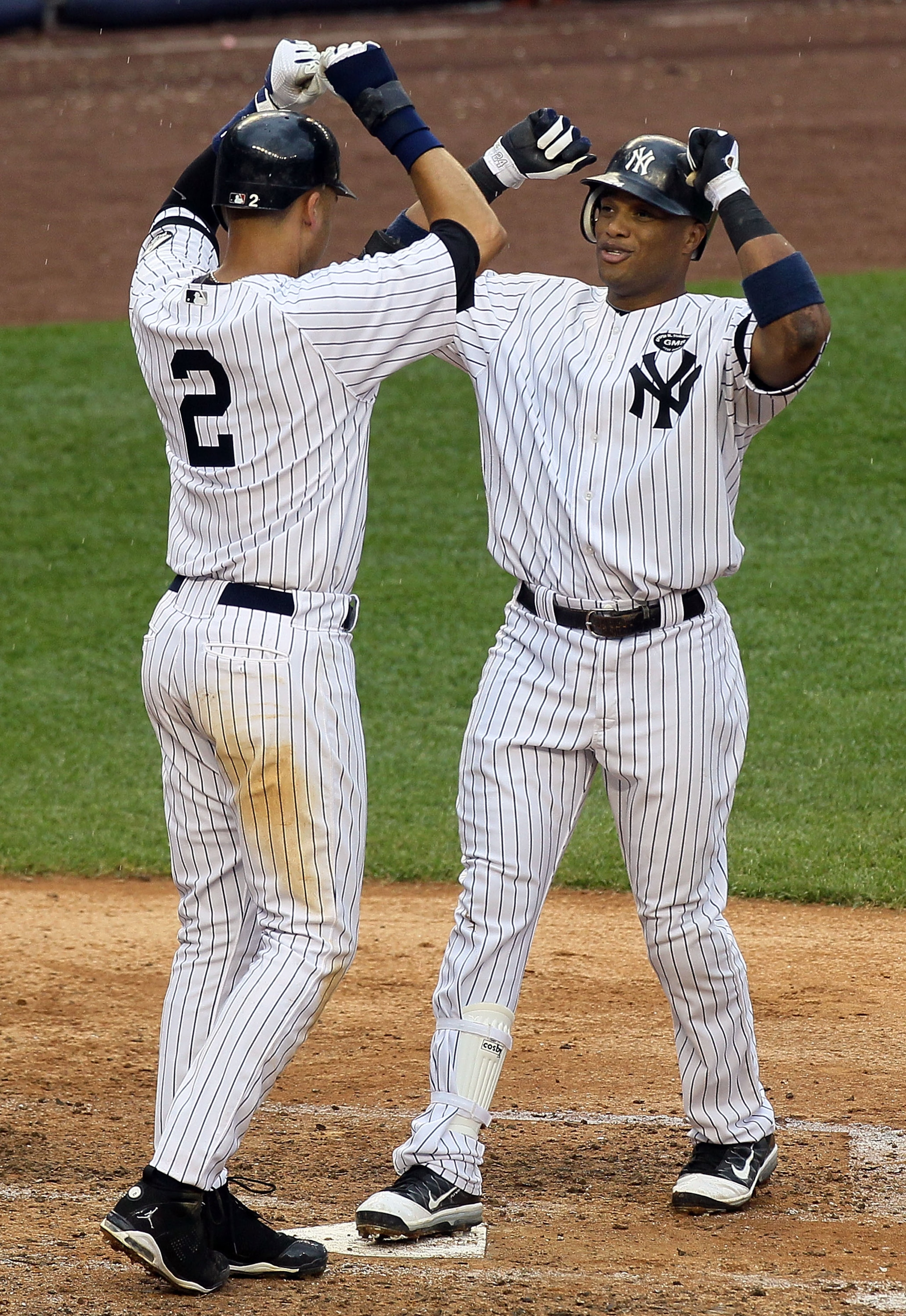 NEW YORK - AUGUST 22:  Robinson Cano #24 of the New York Yankees celebrates his fifth inning grand slam home run against the Seattle Mariners with teammate Derek Jeter #2 on August 22, 2010 at Yankee Stadium in the Bronx borough of New York City.  (Photo