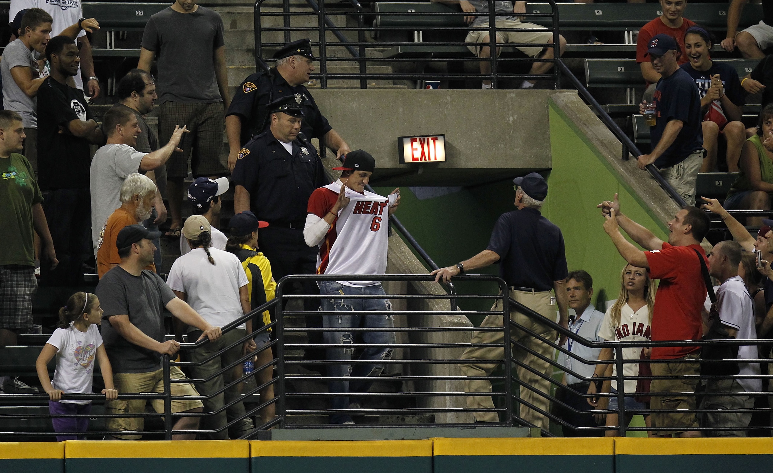 CLEVELAND - JULY 28: A fan wearing a LeBron James Miami Heat jersey at a Cleveland Indians game is escorted out of the ballpark by police while playing the New York Yankees on July 28, 2010 at Progressive Field in Cleveland, Ohio.  (Photo by Gregory Shamu