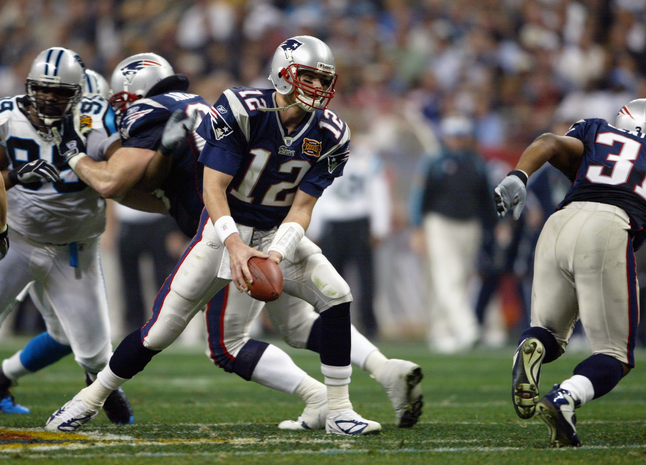 HOUSTON - FEBRUARY 1:  Quarterback Tom Brady #12 of the New England Patriots looks to toss the ball to a running back against the Carolina Panthers during Super Bowl XXXVIII at Reliant Stadium on February 1, 2004 in Houston, Texas.  The Patriots defeated