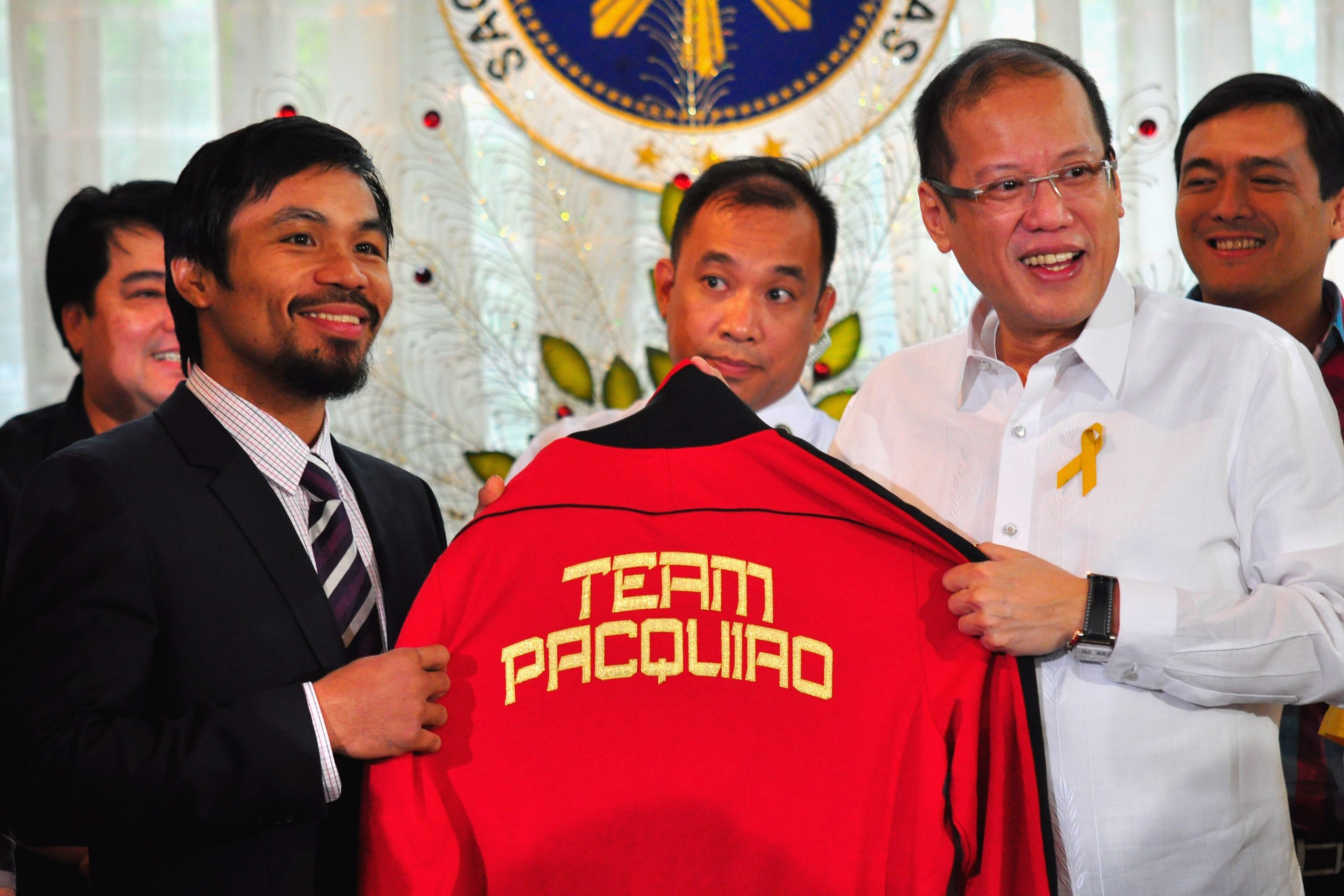 MANILA, PHILIPPINES - NOVEMBER 20:  Boxer and congressman, Manny Pacquiao gives President Benigno Aquino III a shirt and memorabilia following his win of the WBC super welterweight crown against Mexican Antonio Margarito on November 20, 2010 in Manila, Ph