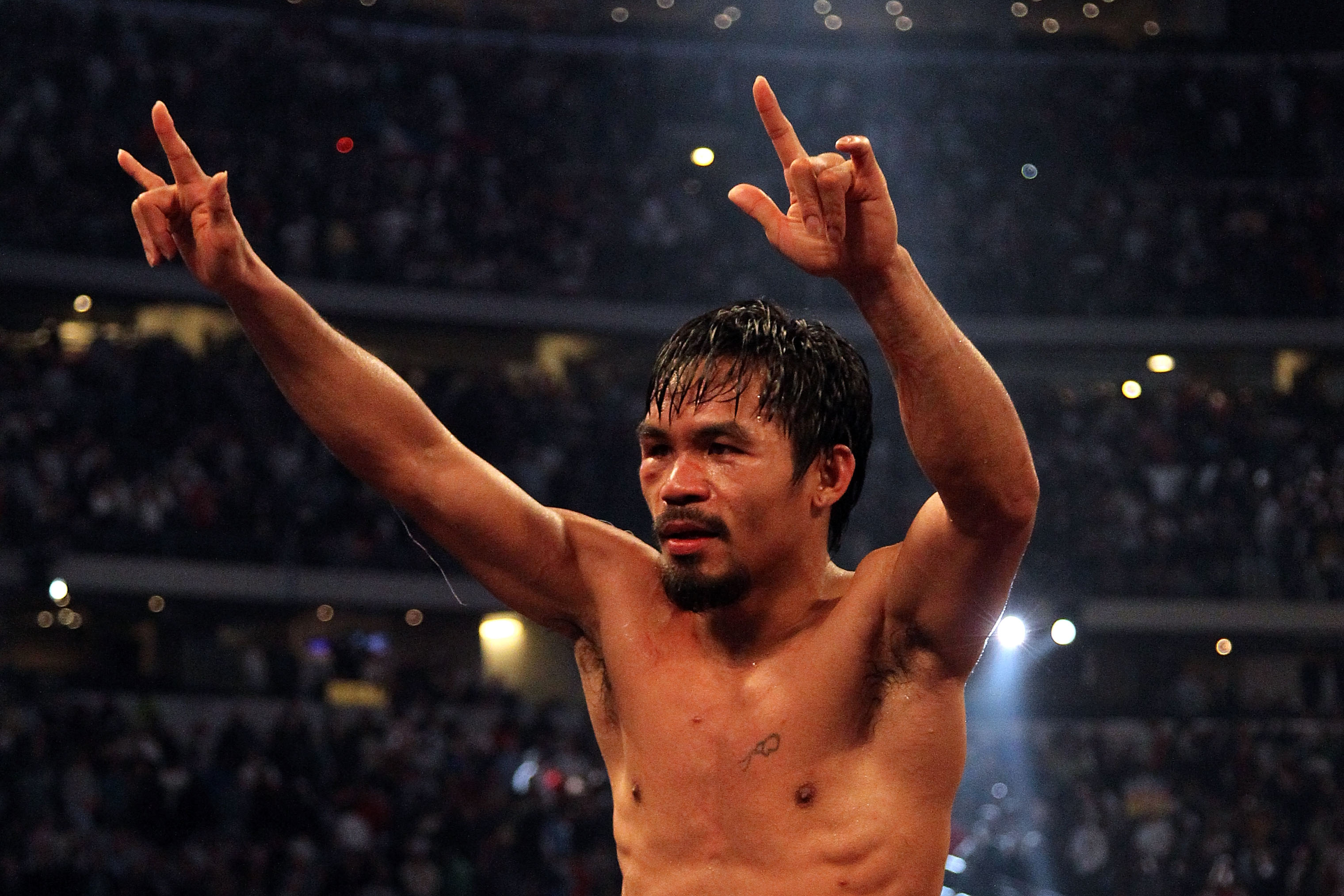 ARLINGTON, TX - MARCH 13:  Manny Pacquiao of the Philippines celebrates in the ring after defeating Joshua Clottey of Ghana during the WBO welterweight title fight at Cowboys Stadium on March 13, 2010 in Arlington, Texas. Pacquiao defeated Clottey by unan