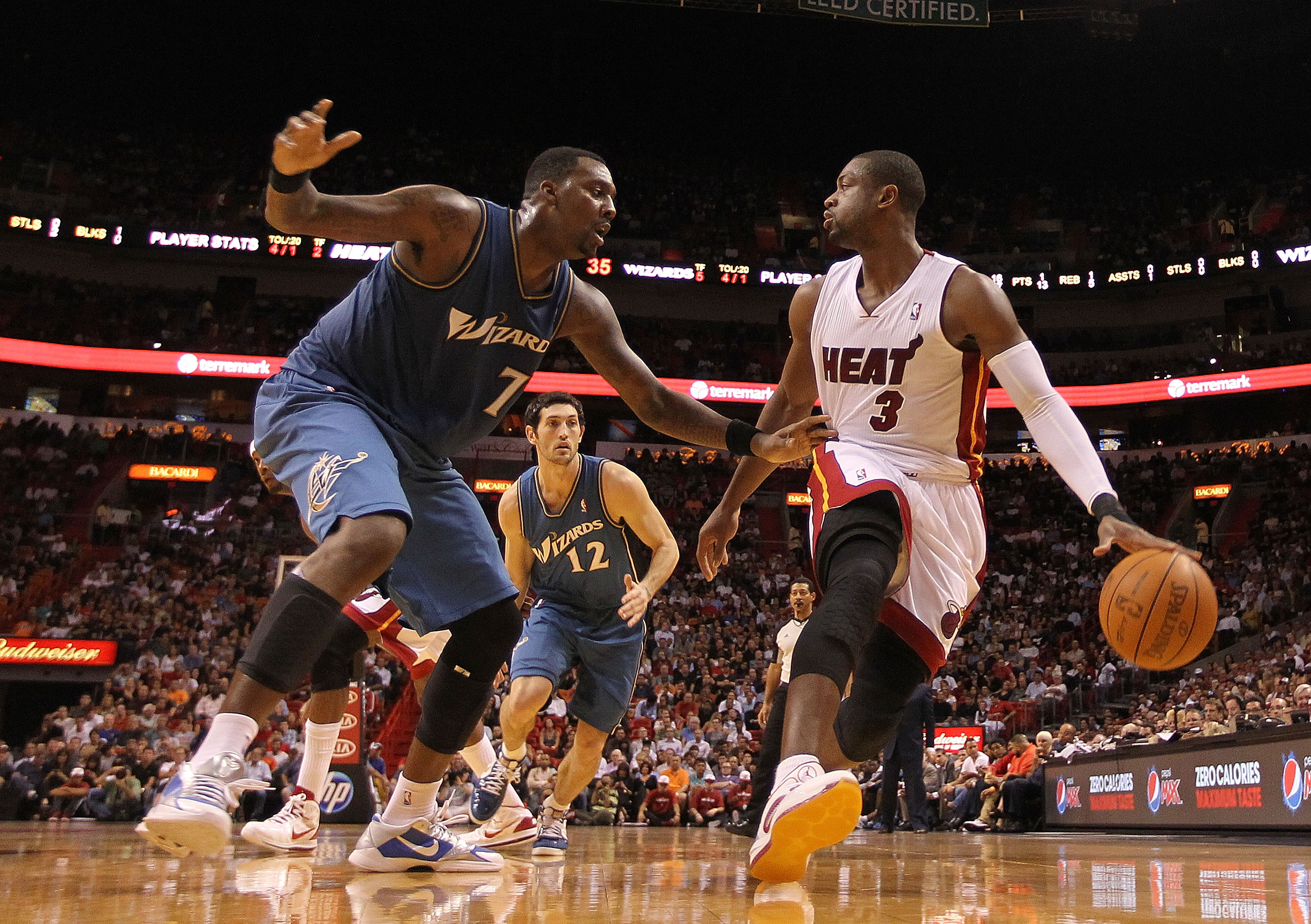 MIAMI, FL - NOVEMBER 29:  Dwyane Wade #3 of the Miami Heat dribbles around Andray Blatche #7 of the Washington Wizards  during a game at American Airlines Arena on November 29, 2010 in Miami, Florida. NOTE TO USER: User expressly acknowledges and agrees t