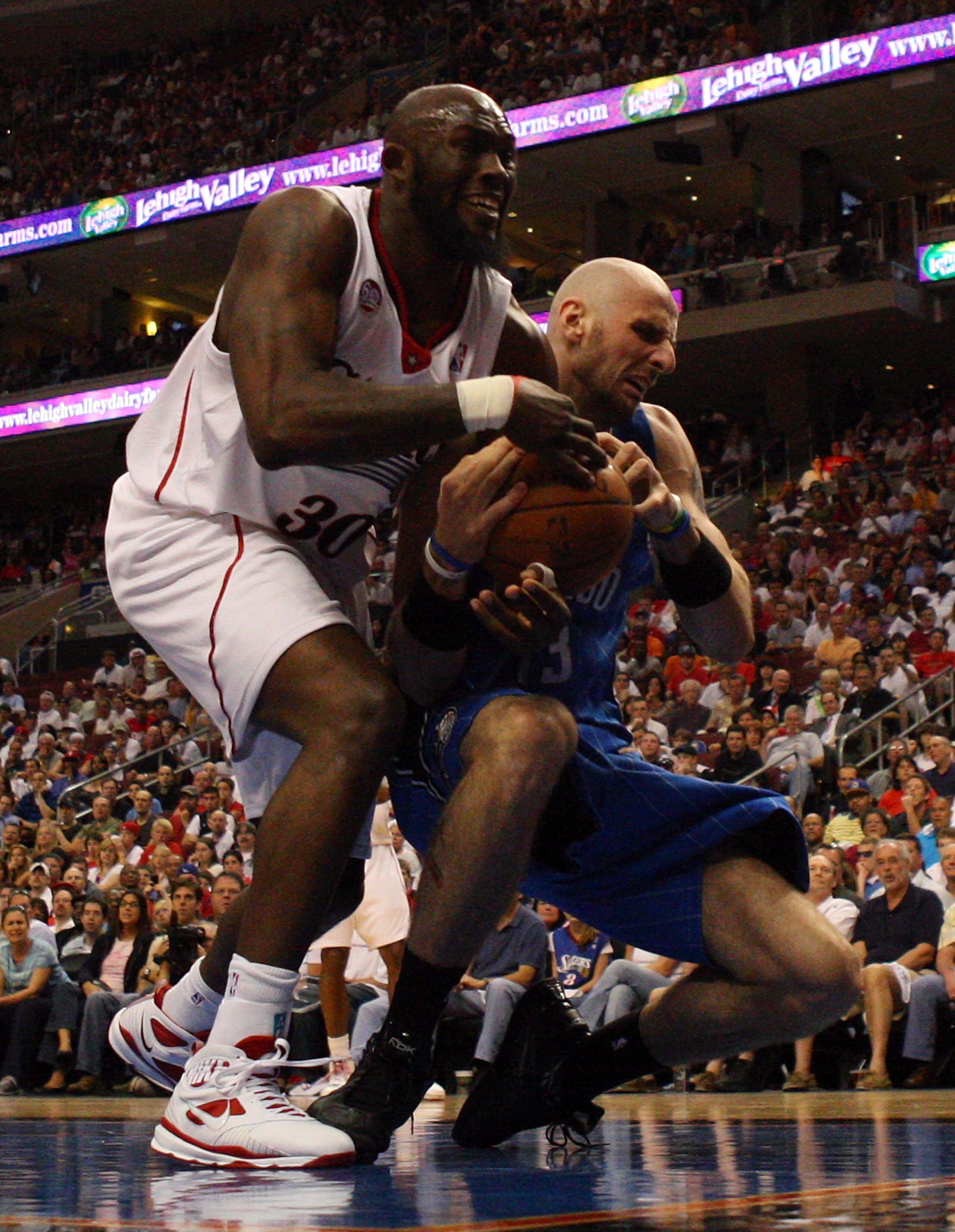 PHILADELPHIA - APRIL 26: Reggie Evans #33 of the Philadelphia 76ers battles for the ball against Marcin Gortat #13 of the Orlando Magic during Game Four of the Eastern Conference Quarterfinals during the 2009 NBA Playoffs at the Wachovia Center on April PHILADELPHIA - APRIL 26: Reggie Evans #33 of the Philadelphia 76ers battles for the ball against Marcin Gortat #13 of the Orlando Magic during Game Four of the Eastern Conference Quarterfinals during the 2009 NBA Playoffs at the Wachovia Center on April