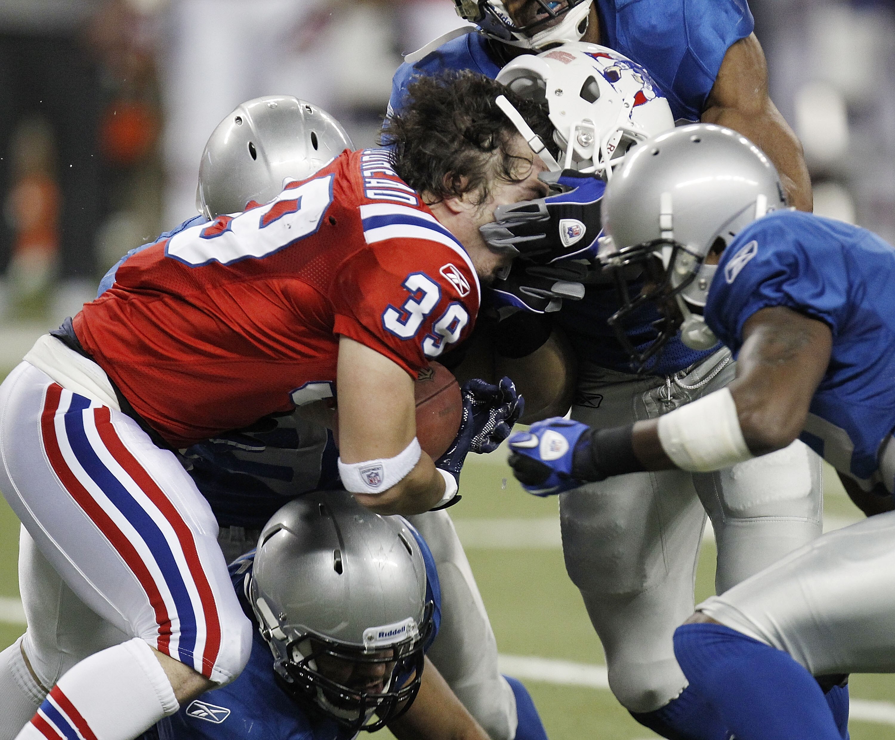 DETROIT - NOVEMBER 25:  Danny Woodhead #39 of the New England Patriots loses his helmet while being tackled by Amari Spievey #42 of the Detroit Lions on November 25, 2010 at Ford Field in Detroit, Michigan.  (Photo by Gregory Shamus/Getty Images)