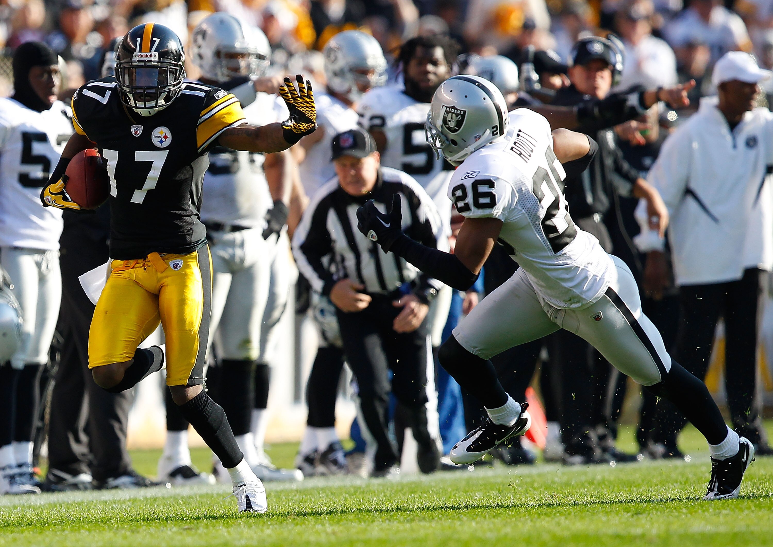 PITTSBURGH, PA - NOVEMBER 21:  Mike Wallace #17 of the Pittsburgh Steelers attempts to outrun a tackle by Stanford Routt #26 of the Oakland Raiders during the game on November 21, 2010 at Heinz Field in Pittsburgh, Pennsylvania.  (Photo by Jared Wickerham