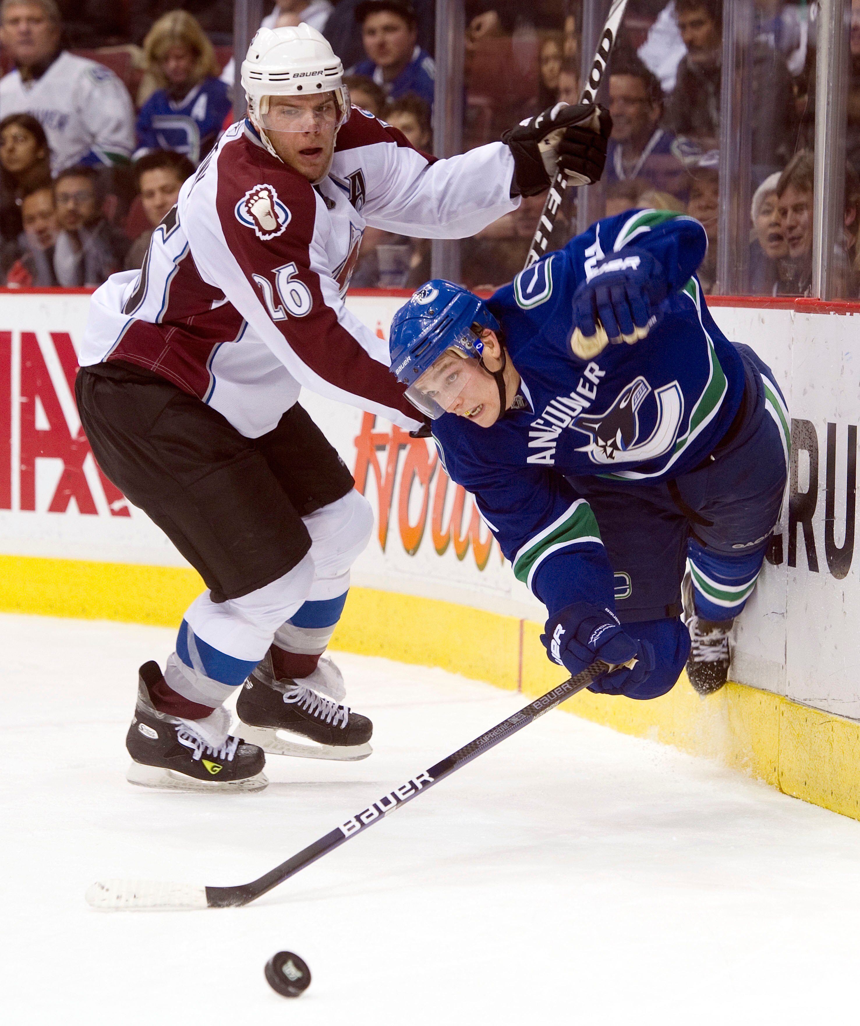 VANCOUVER, CANADA - NOVEMBER 24: Mason Raymond #21 of the Vancouver Canucks falls to the ice after getting tripped up by Paul Stastny #26 of the Colorado Avalanche while battling for the loose puck during the second period in NHL action on November 24, 20