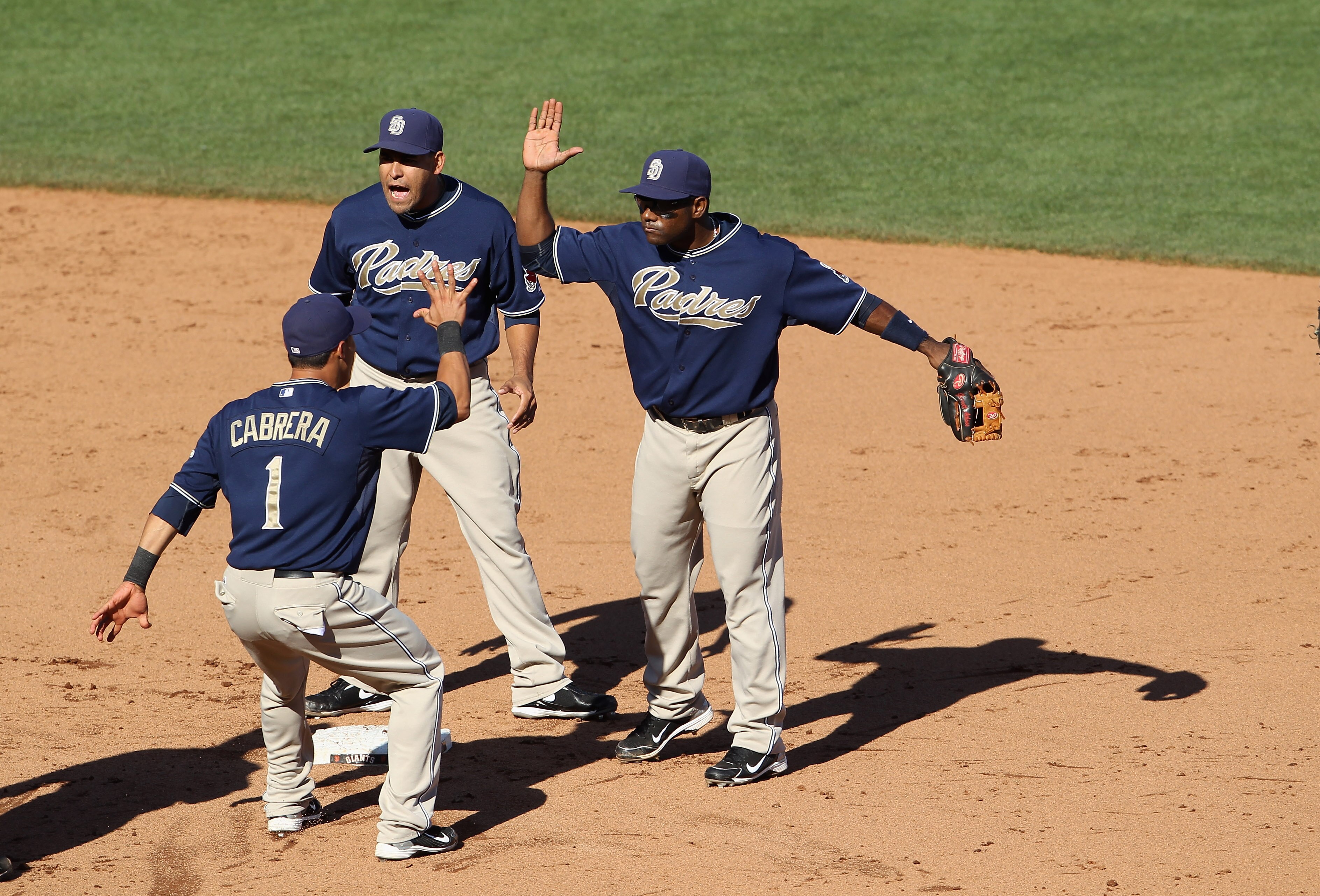 SAN FRANCISCO - OCTOBER 02:  Miguel Tejada #10, Everth Cabrera #1 and Oscar Salazar #14 of the San Diego Padres celebrate after they beat the San Francisco Giants at AT&T Park on October 2, 2010 in San Francisco, California.  (Photo by Ezra Shaw/Getty Ima