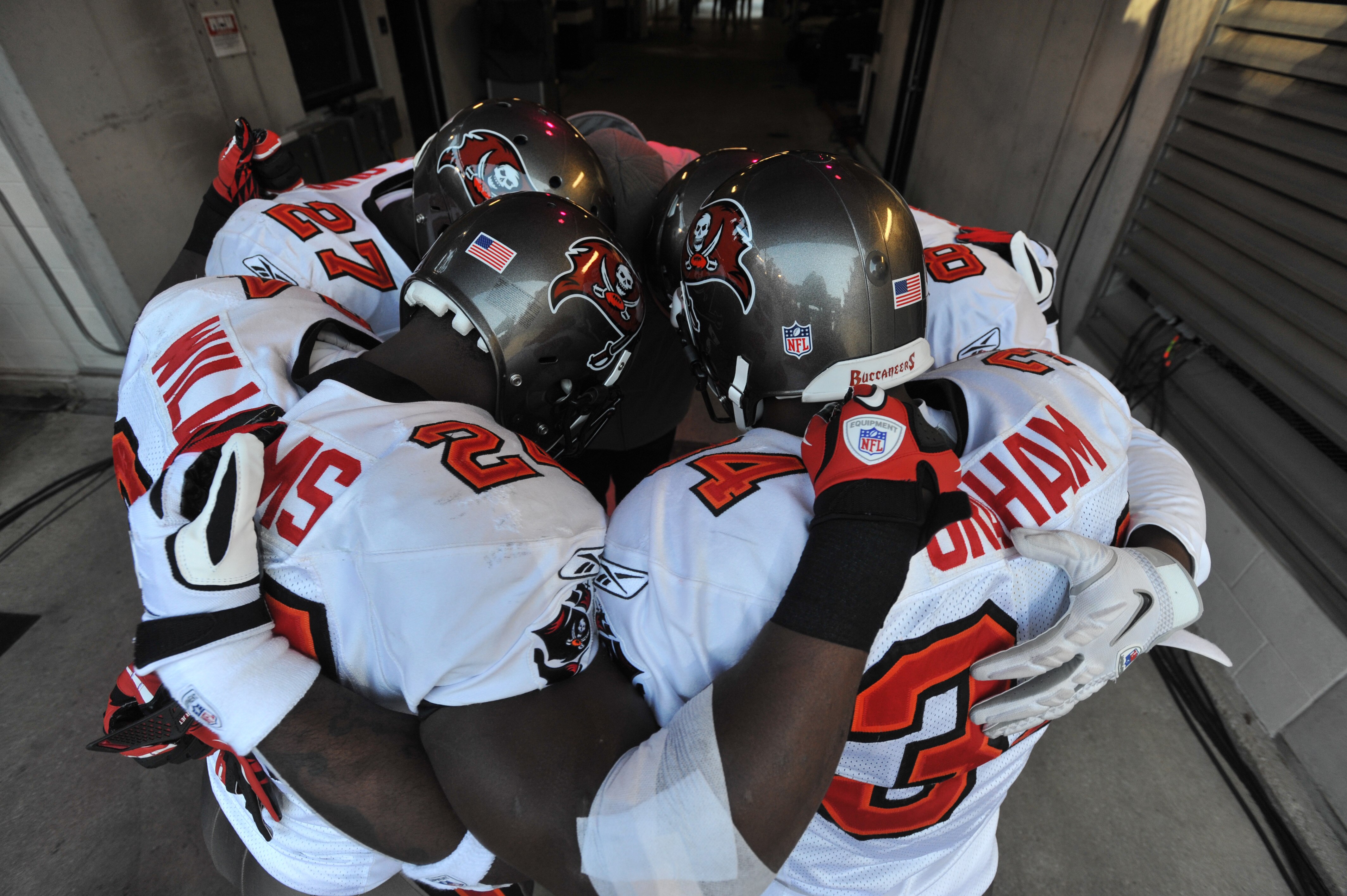 BALTIMORE, MD - NOVEMBER 28:  Carnell Williams #24 and Earnest Graham #34 of the Tampa Bay Buccaneers huddle with teammates before the game against the Baltimore Ravens at M&T Bank Stadium on November 28, 2010 in Baltimore, Maryland. The Ravens defeated t
