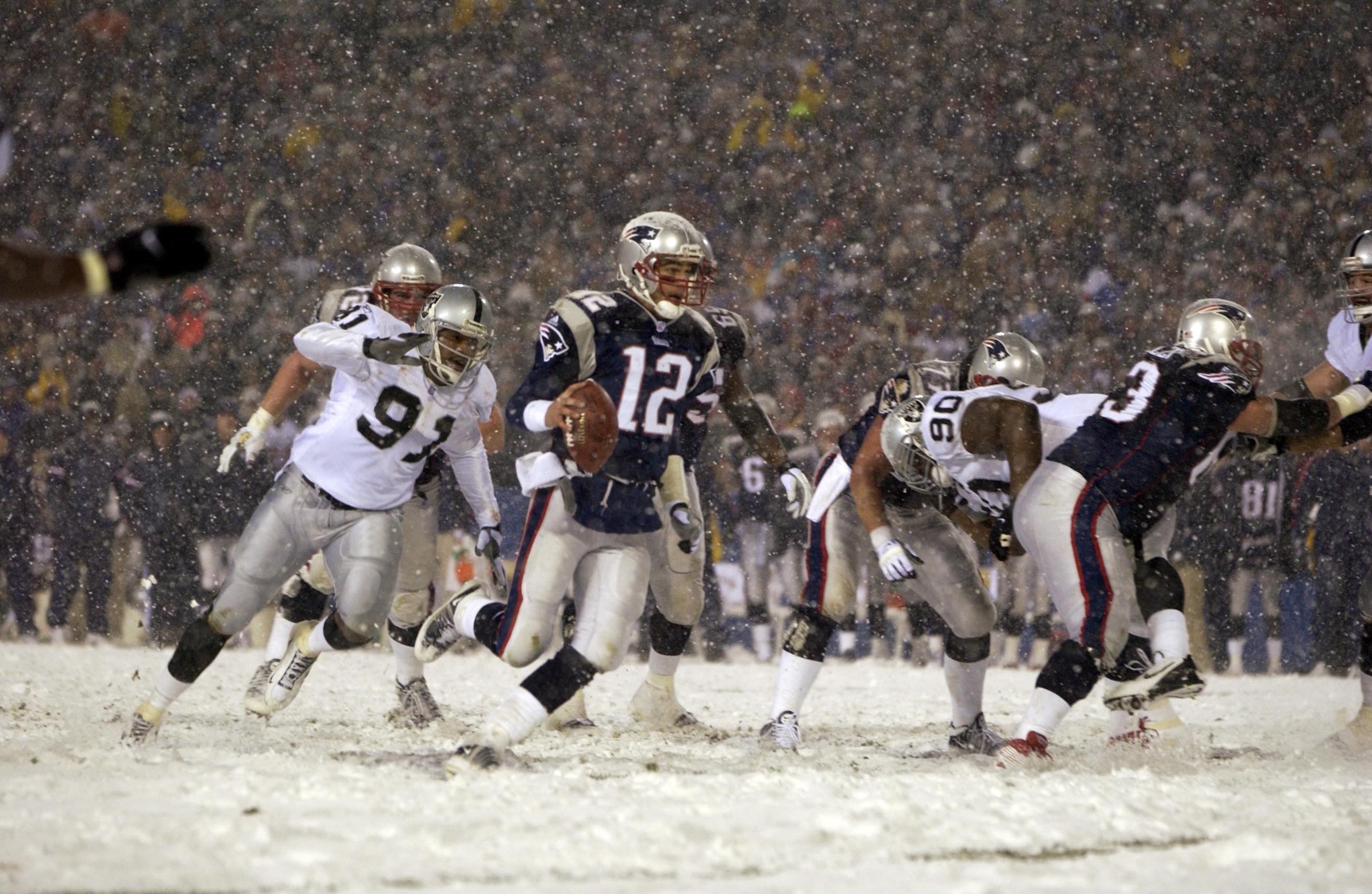 19 Jan 2002:  Quarterback  Tom Brady #12 of the New England Patriots runs in for a touchdown over the defense of Regan Upshaw #91of the Oakland Raiders during the AFC playoff game at Foxboro Stadium in Foxboro, Massachuesetts. The Patriots came from behin