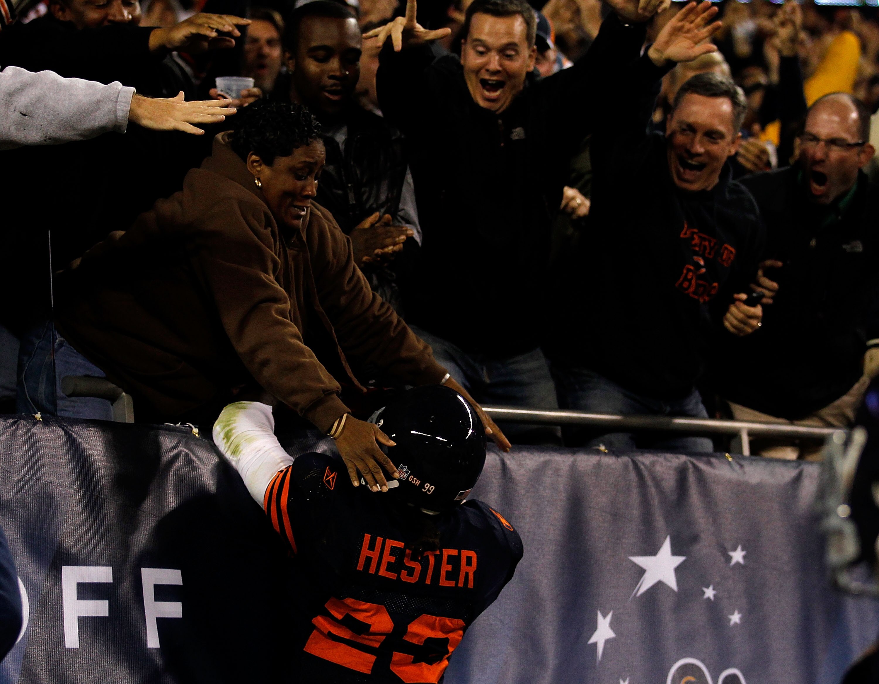 CHICAGO - SEPTEMBER 27:  Devin Hester #23 of the Chicago Bears climbs up into the stands to celebrate with fans after he scored a 62-yard punt return touchdown in the fourth quarter against the Green Bay Packers at Soldier Field on September 27, 2010 in C