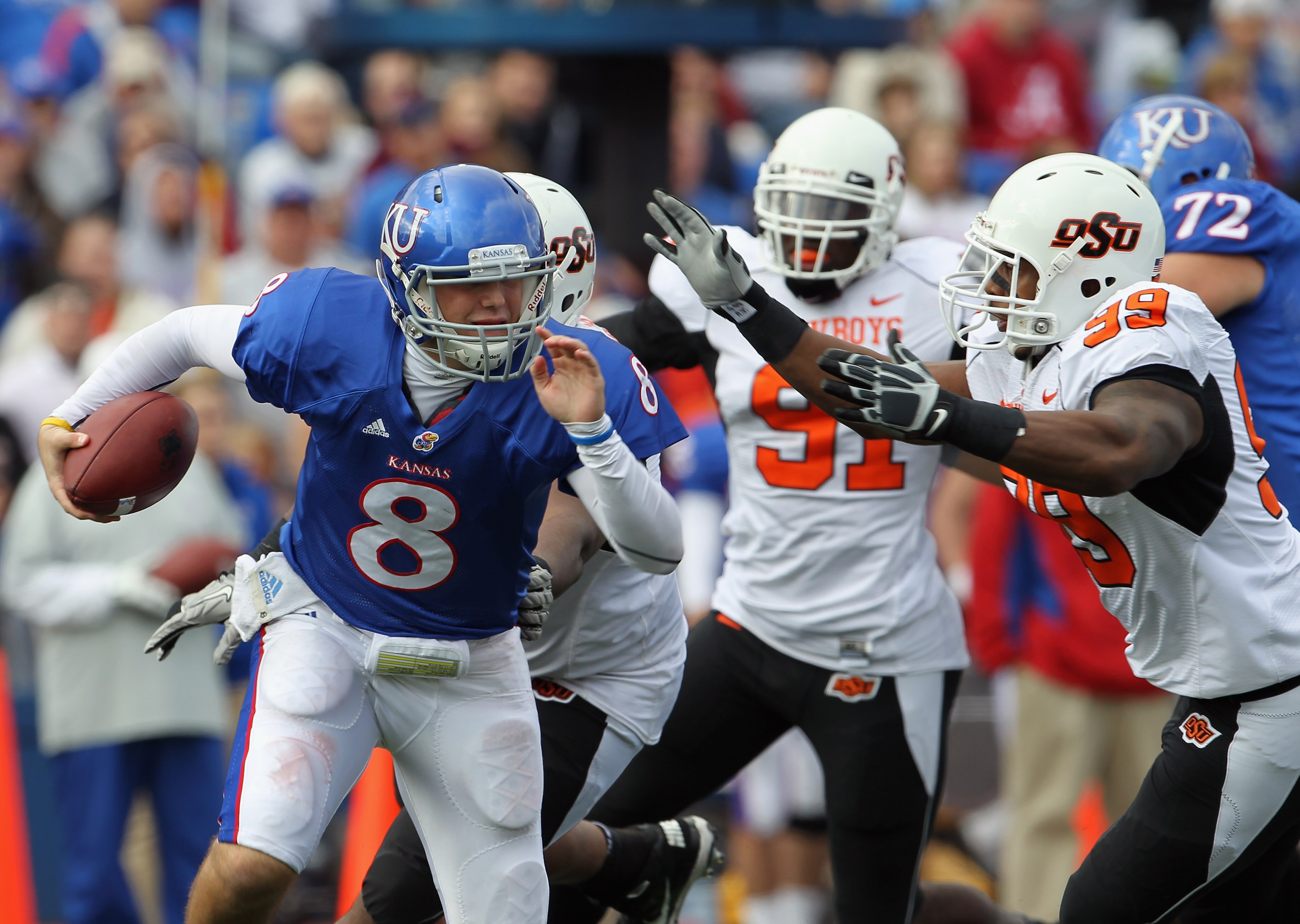 LAWRENCE, KS - NOVEMBER 20:  Quarterback Quinn Mecham #8 of the Kansas Jayhawks is sacked by Richetti Jones #99 during the game on November 20, 2010 at Memorial Stadium in Lawrence, Kansas.  (Photo by Jamie Squire/Getty Images)