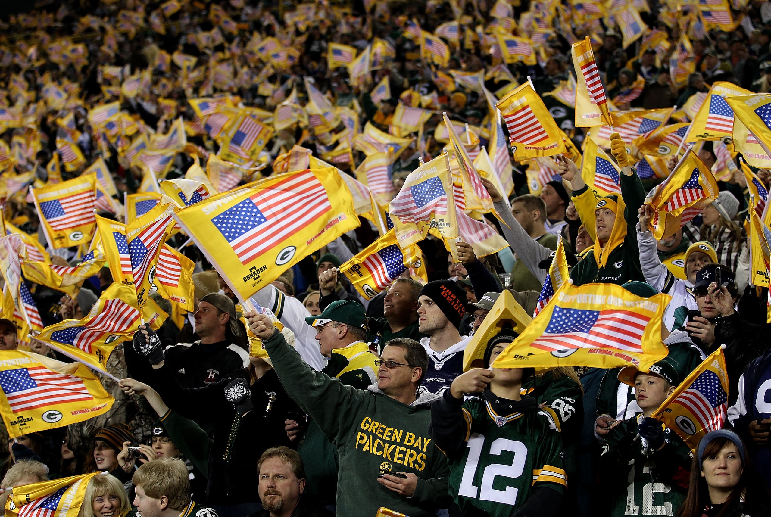 GREEN BAY, WI - NOVEMBER 07: Fans of the Green Bay Packers wave American flags during a pre-game ceremony before a game against the Dallas Cowboys at Lambeau Field on November 7, 2010 in Green Bay, Wisconsin. (Photo by Jonathan Daniel/Getty Images)