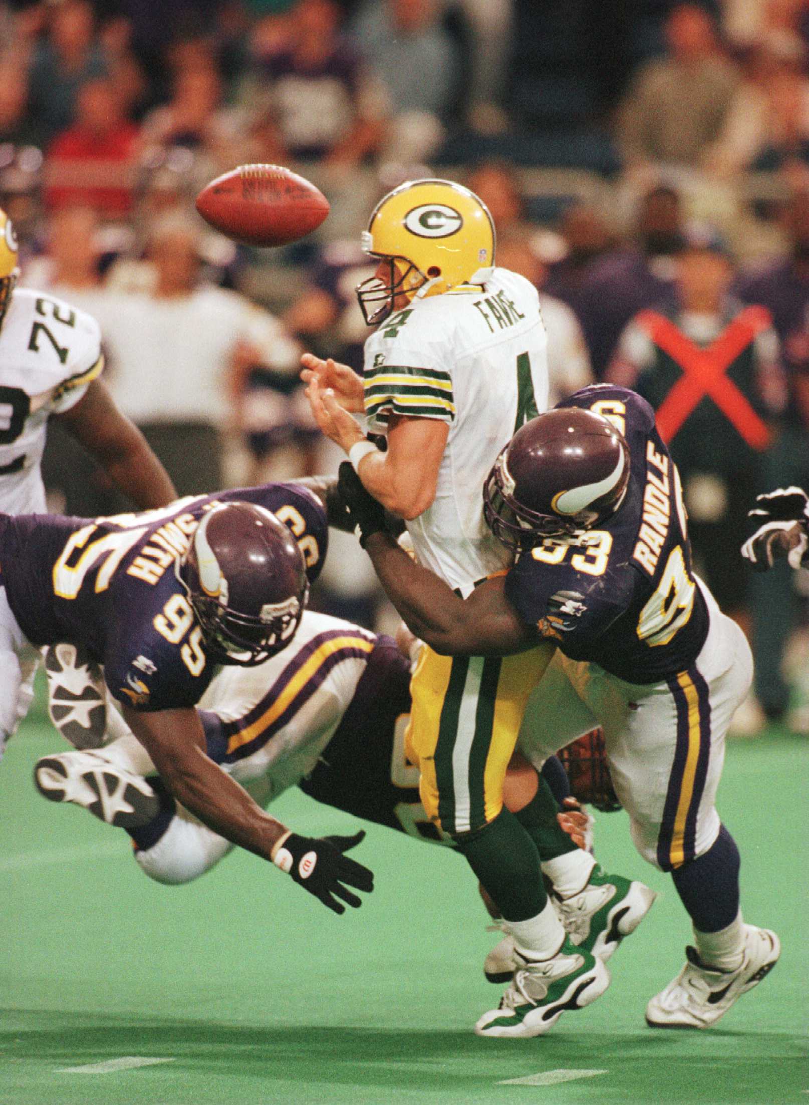 22 Sep 1996: Quarterback Brett Favre #4 of the Green Bay Packers fumbles the ball as he is tackled by Fernando Smith #95 and John Randle #93 of the Minnesota Vikings during the second half at the Metrodome in Minneapolis, Minnesota. The Vikings defeated t