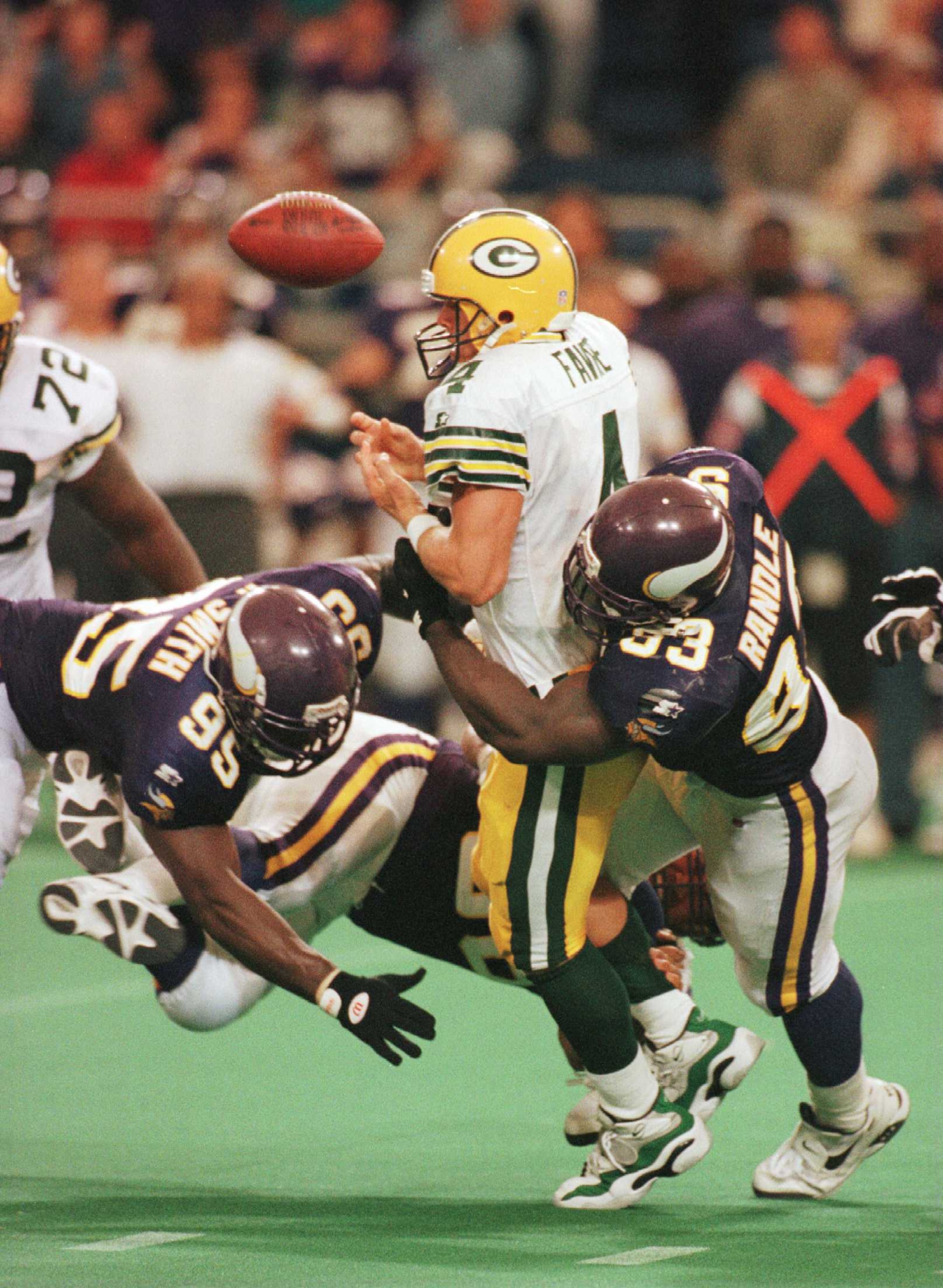 22 Sep 1996: Quarterback Brett Favre #4 of the Green Bay Packers fumbles the ball as he is tackled by Fernando Smith #95 and John Randle #93 of the Minnesota Vikings during the second half at the Metrodome in Minneapolis, Minnesota. The Vikings defeated t