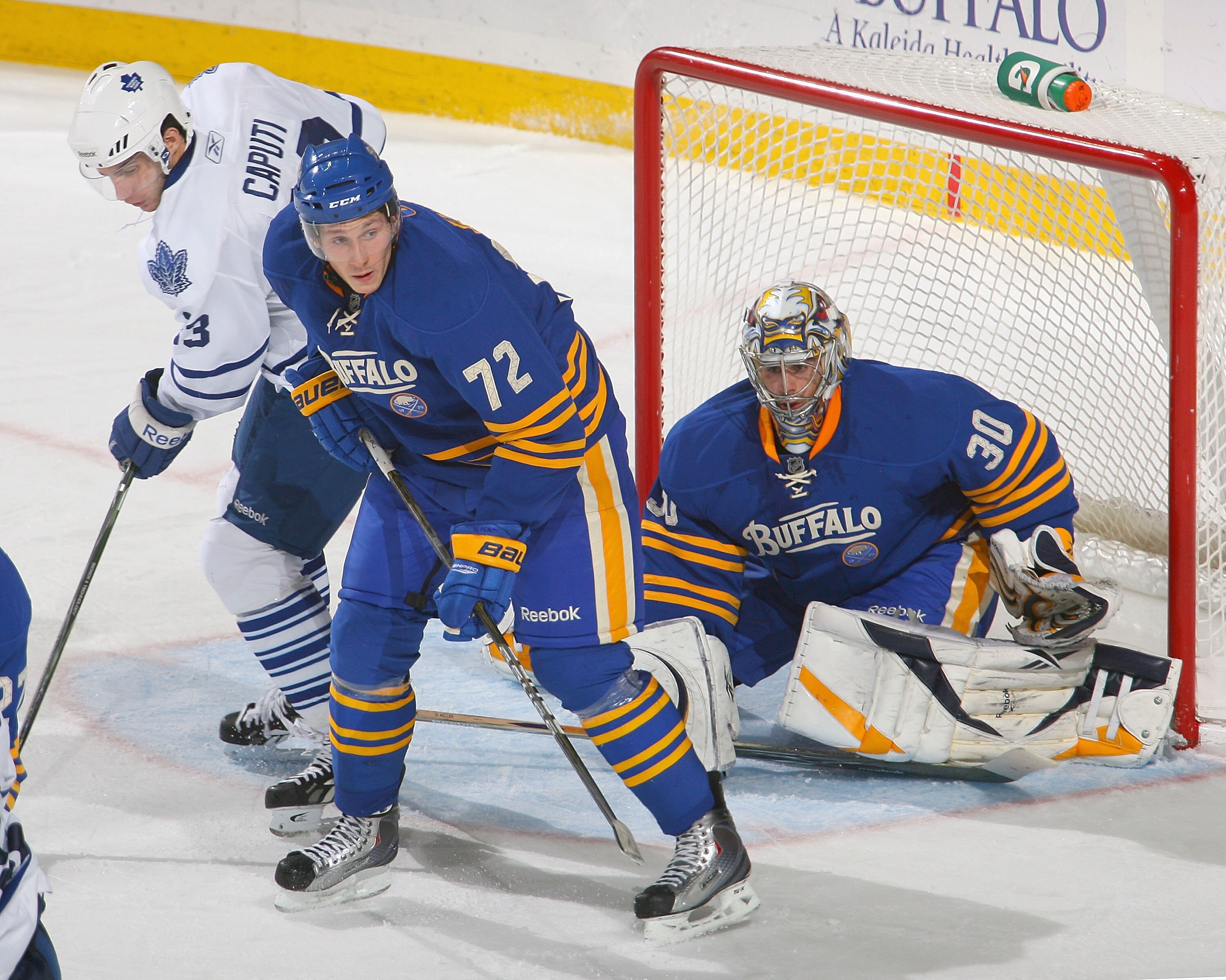 BUFFALO, NY - NOVEMBER 26:  Luke Adam #72 and Ryan Miller #30 of the Buffalo Sabres defend against Luca Caputi #33 of the Toronto Maple Leafs at HSBC Arena  on November 26, 2010 in Buffalo, New York. Buffalo won 3-1.  (Photo by Rick Stewart/Getty Images)