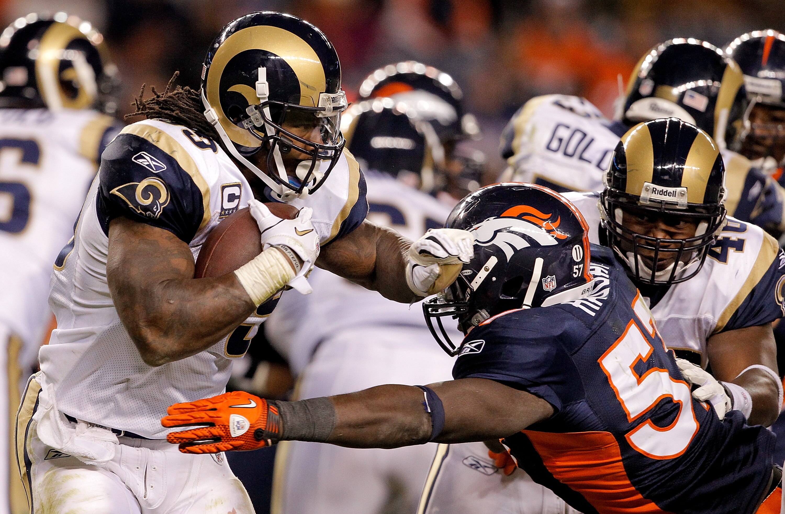 DENVER - NOVEMBER 28:  Running back Steven Jackson #39 of the St. Louis Rams tries to break outside of linebacker Mario Haggan #57 of the Denver Broncos during the fourth quarter at INVESCO Field at Mile High on November 28, 2010 in Denver, Colorado. The