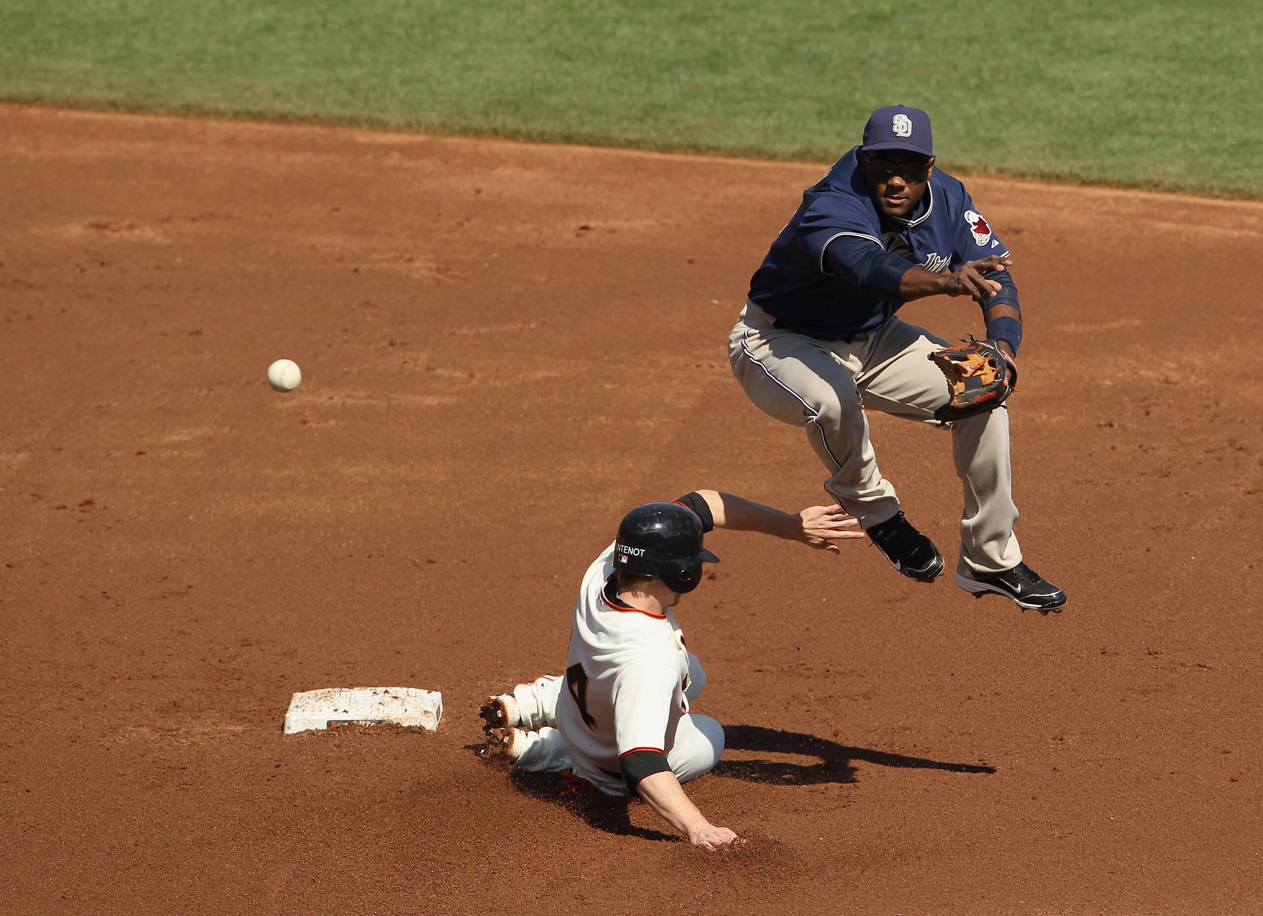 SAN FRANCISCO - OCTOBER 02:  Miguel Tejada #10 of the San Diego Padres turns a double play as Mike Fontenot #14 of the San Francisco Giants slides in to second base at AT&T Park on October 2, 2010 in San Francisco, California.  (Photo by Ezra Shaw/Getty I