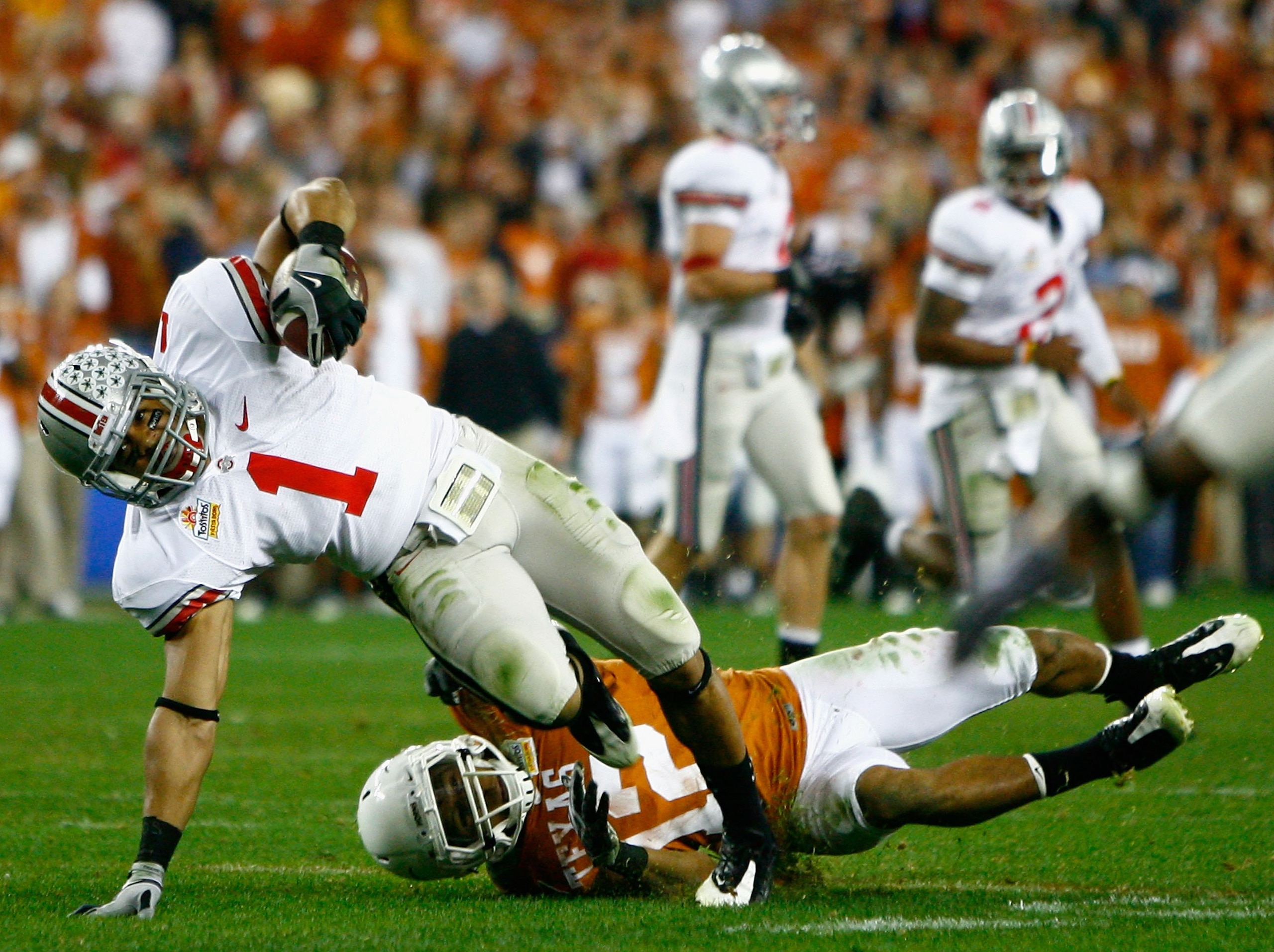 GLENDALE, AZ - JANUARY 05:  Runningback Daniel Herron #1 of the Ohio State Buckeyes is tackled by Earl Thomas #12 of the Texas Longhorns during the Tostitos Fiesta Bowl Game on January 5, 2009 at University of Phoenix Stadium in Glendale, Arizona.  (Photo