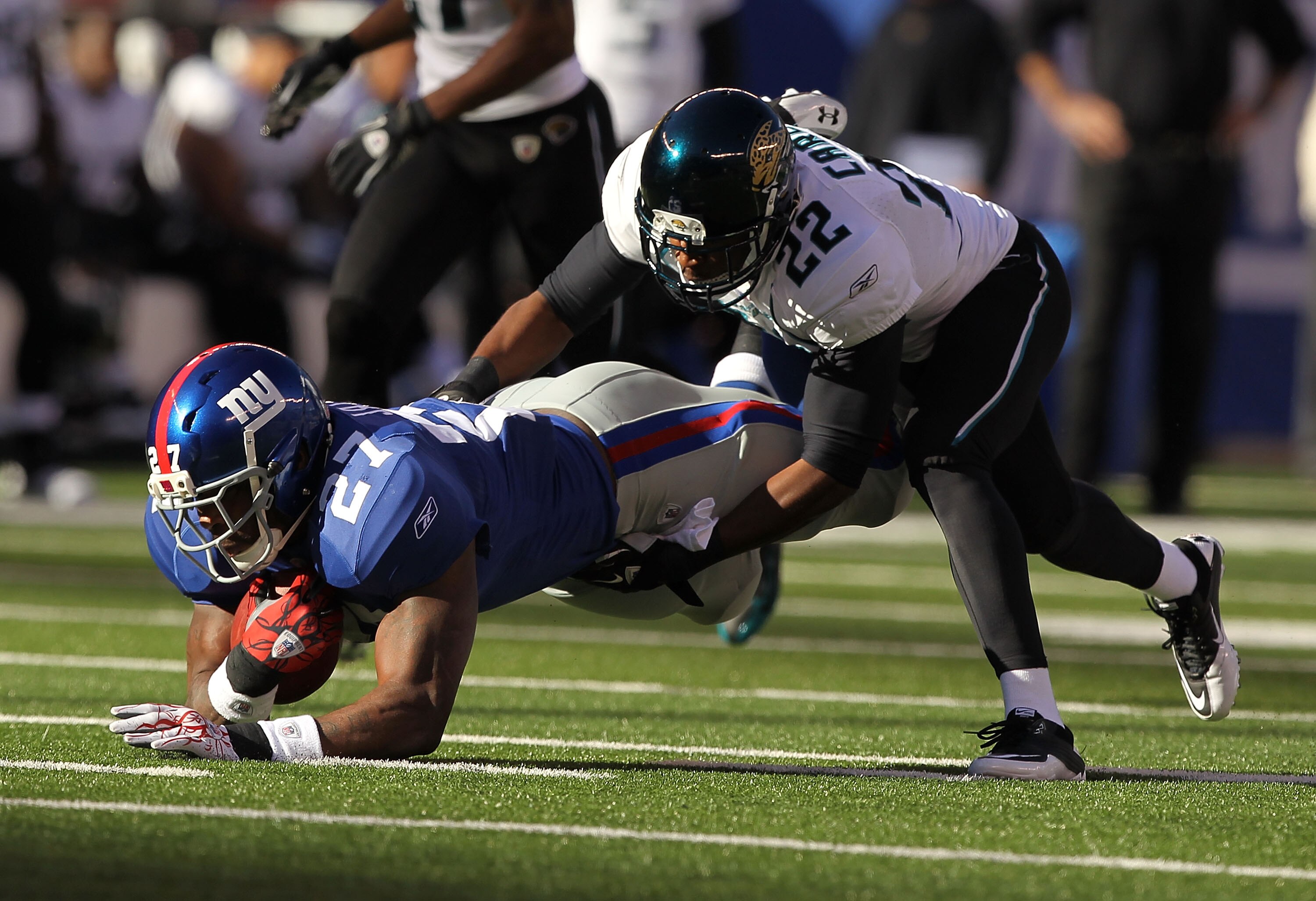 EAST RUTHERFORD, NJ - NOVEMBER 28:  Brandon Jacobs #27 of the New York Giants is tackled by Don Carey #22 of the Jacksonville Jaguars during their game on November 28, 2010 at The New Meadowlands Stadium in East Rutherford, New Jersey.  (Photo by Al Bello