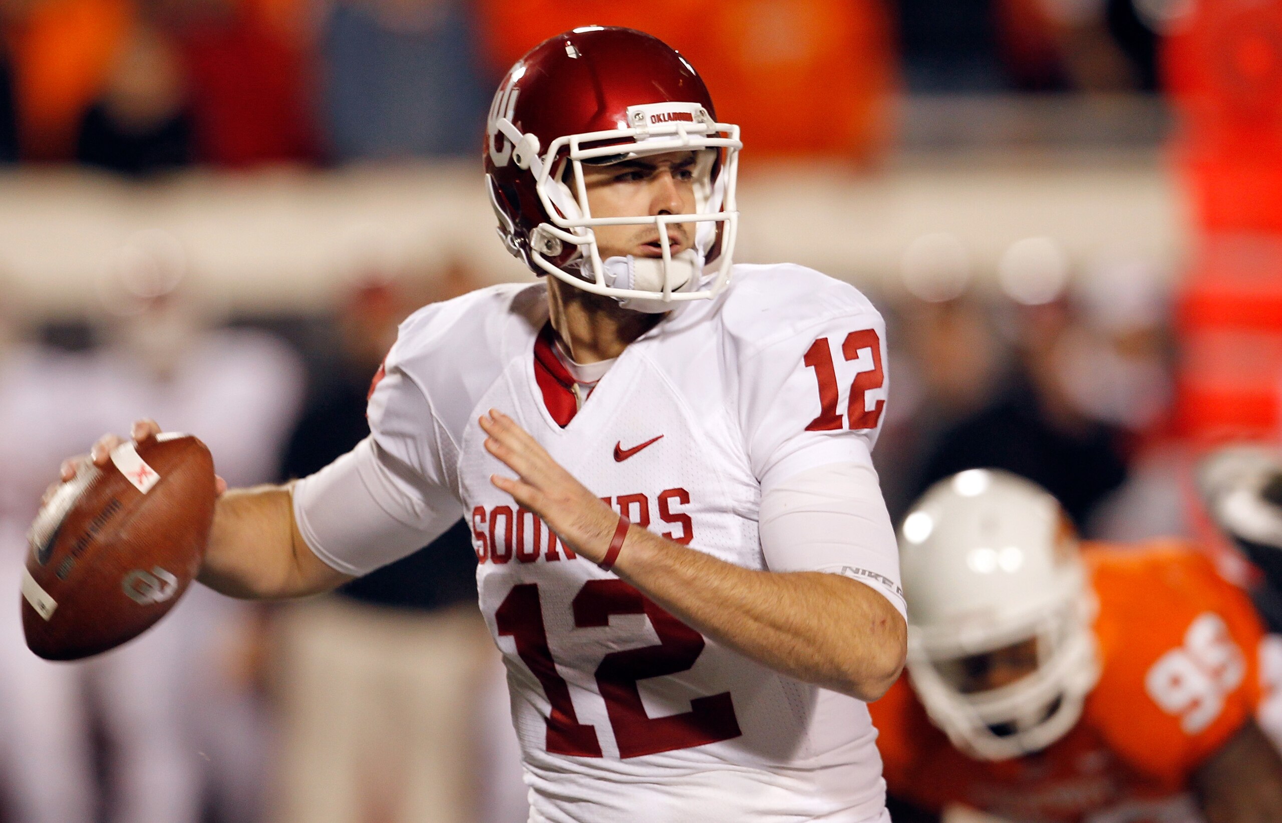 STILLWATER, OK - NOVEMBER 27:  Quarterback Landry Jones #12 of the Oklahoma Sooners looks for an open receiver against the Oklahoma State Cowboys at Boone Pickens Stadium on November 27, 2010 in Stillwater, Oklahoma.  (Photo by Tom Pennington/Getty Images