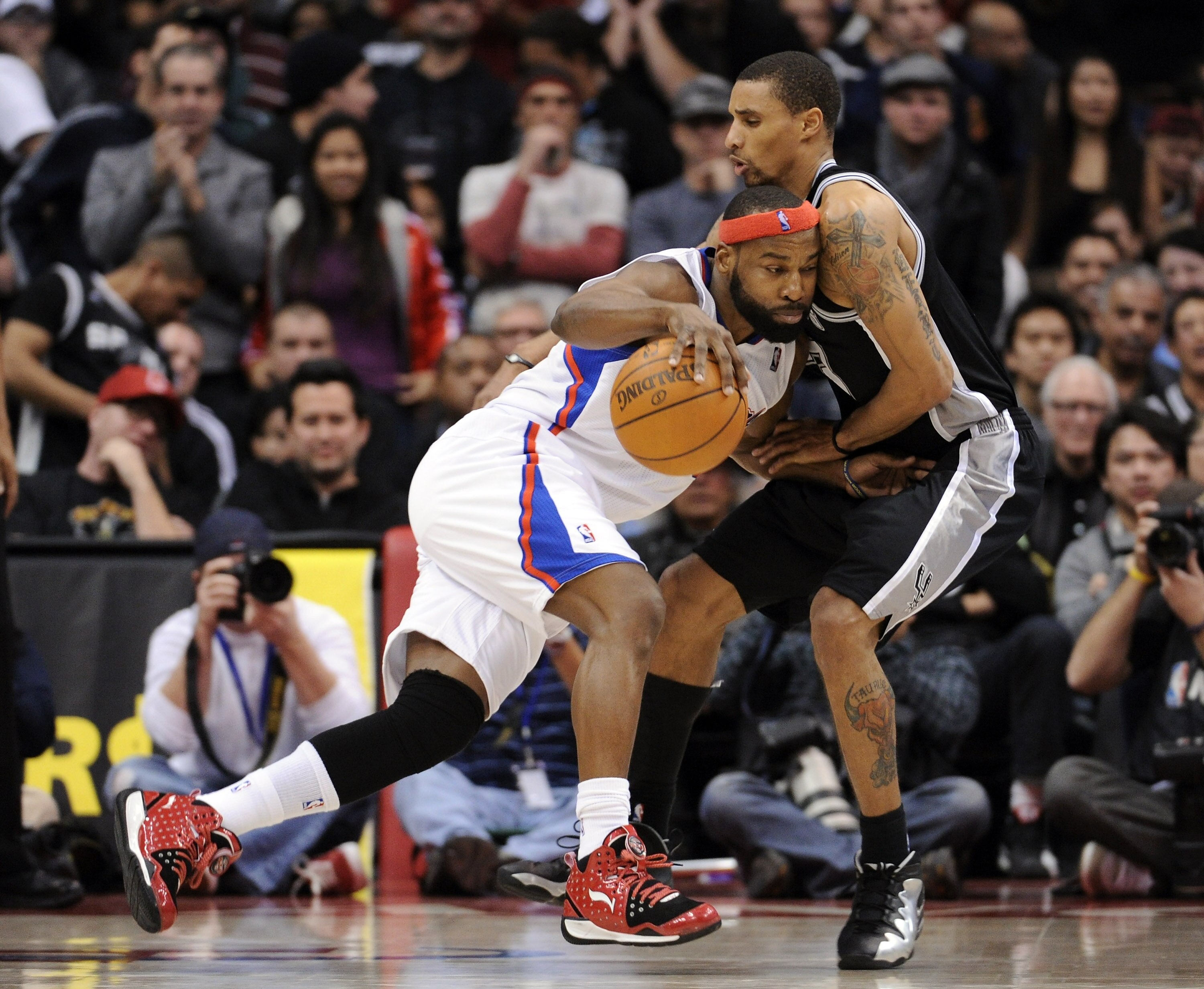 LOS ANGELES, CA - DECEMBER 01:  Baron Davis #5 of the Los Angeles Clippers dribbles to the basket as he is defended by George Hill #3 of the San Antonio Spurs during a 90-85 Clipper win at the Staples Center on December 1, 2010 in Los Angeles, California.