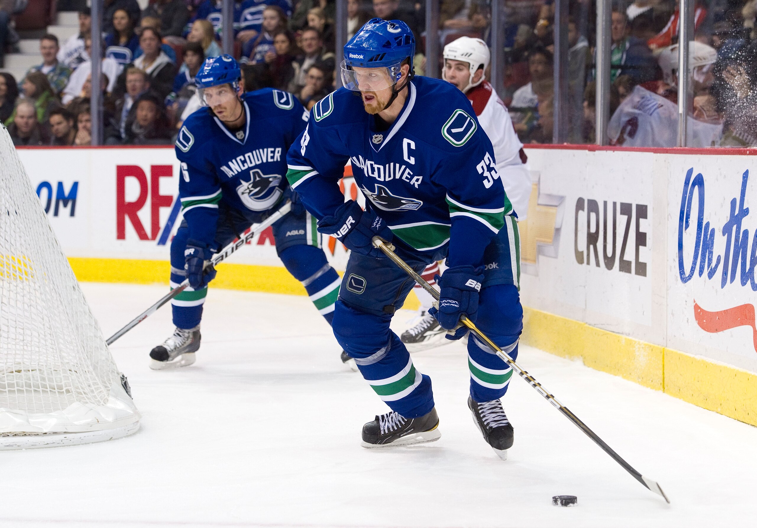 VANCOUVER, CANADA - NOVEMBER 21: Henrik Sedin #33 of the Vancouver Canucks skates out from behind the net with the puck while Mikael Samuelsson #26 looks on during the second period in NHL action against the Phoenix Coyotes on November 21, 2010 at Rogers