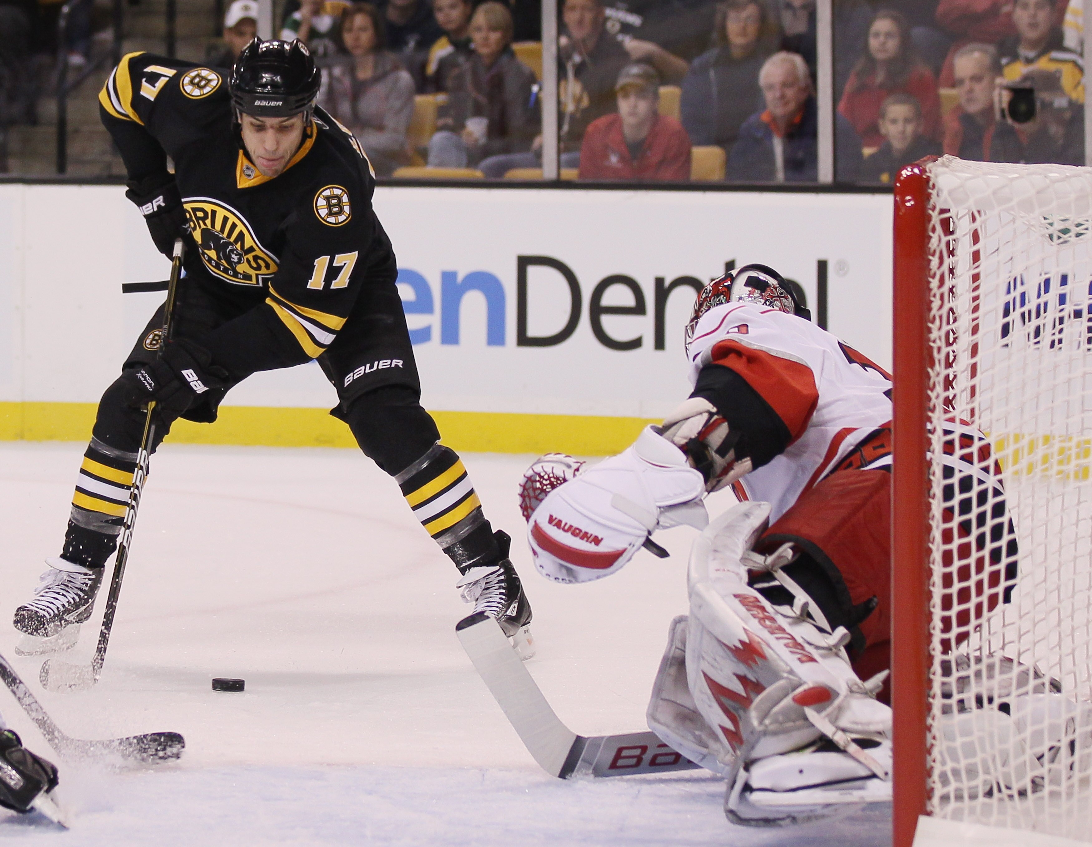 BOSTON - NOVEMBER 26:  Milan Lucic #17 of the Boston Bruins tries to get the puck past Cam Ward #30 of the Carolina Hurricanes on November 26, 2010 at the TD Garden in Boston, Massachusetts.  (Photo by Elsa/Getty Images)