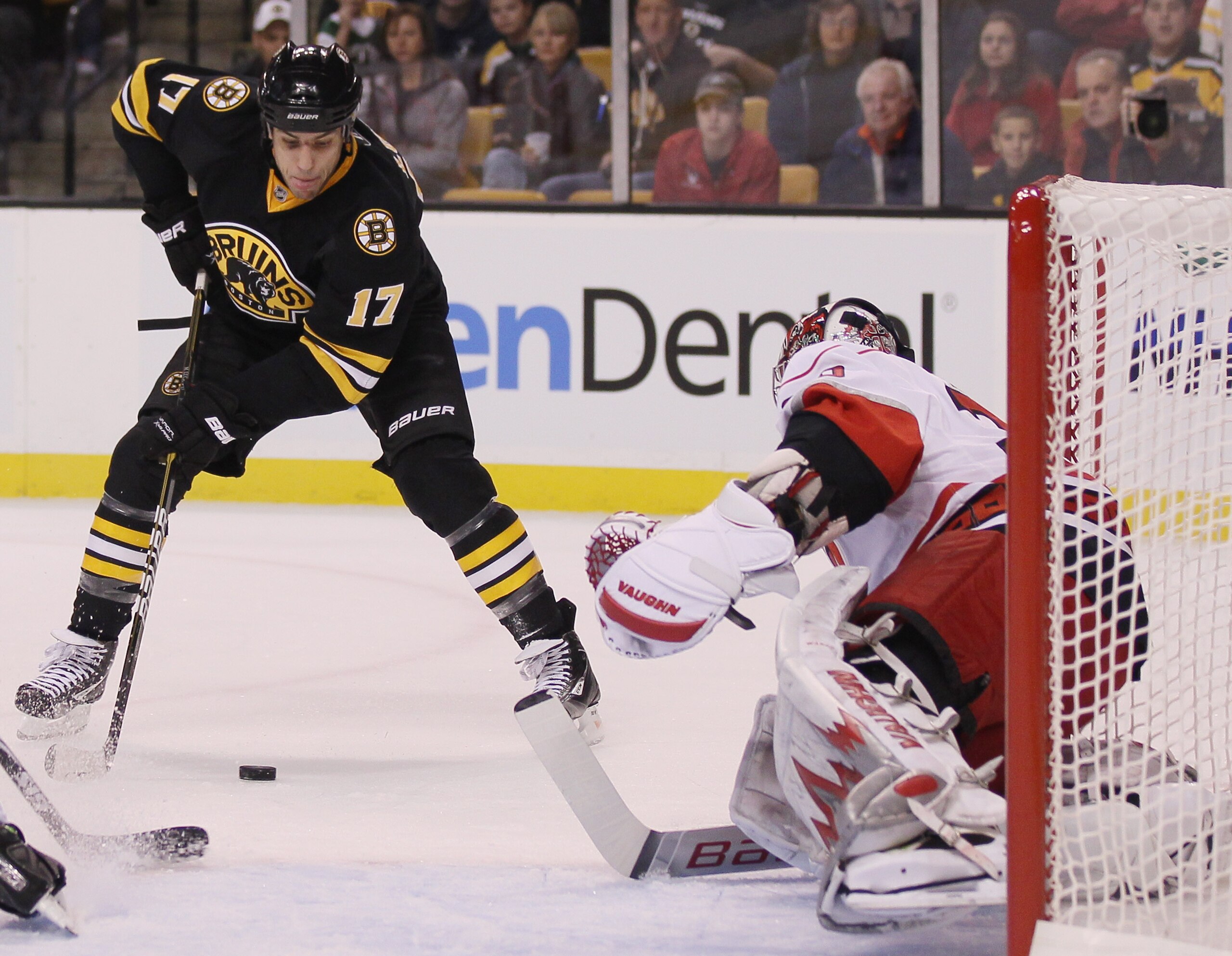 BOSTON - NOVEMBER 26:  Milan Lucic #17 of the Boston Bruins tries to get the puck past Cam Ward #30 of the Carolina Hurricanes on November 26, 2010 at the TD Garden in Boston, Massachusetts.  (Photo by Elsa/Getty Images)