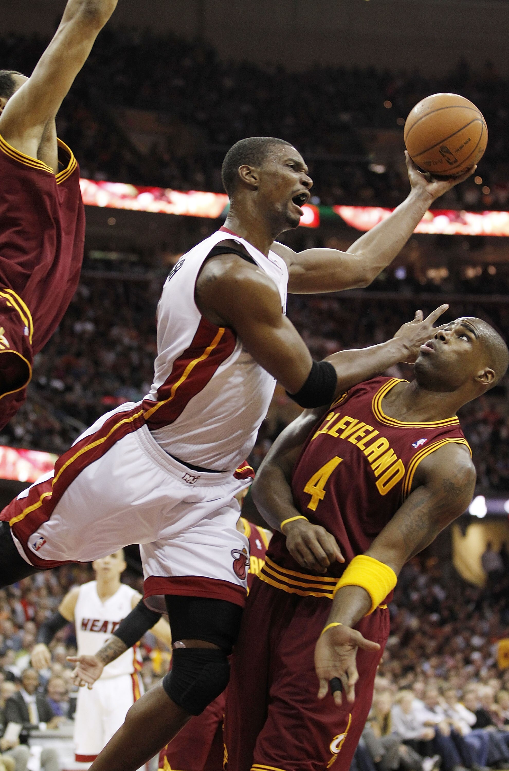 CLEVELAND, OH - DECEMBER 02:  Chris Bosh #1 of the Miami Heat gets a shot off over Antawn Jamison #4 of the Cleveland Cavaliers at Quicken Loans Arena on December 2, 2010 in Cleveland, Ohio. NOTE TO USER: User expressly acknowledges and agrees that, by do