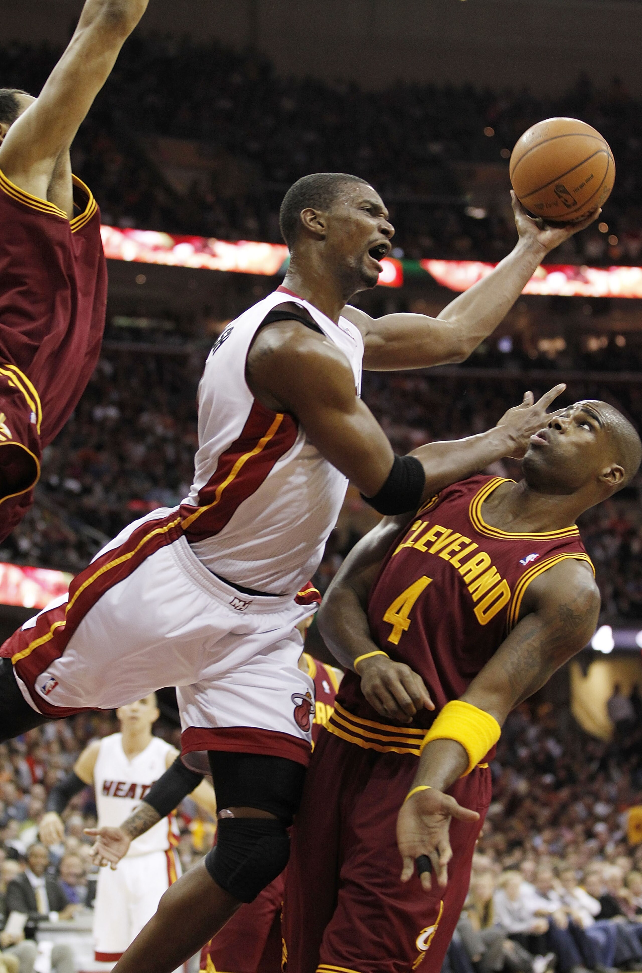 CLEVELAND, OH - DECEMBER 02:  Chris Bosh #1 of the Miami Heat gets a shot off over Antawn Jamison #4 of the Cleveland Cavaliers at Quicken Loans Arena on December 2, 2010 in Cleveland, Ohio. NOTE TO USER: User expressly acknowledges and agrees that, by do